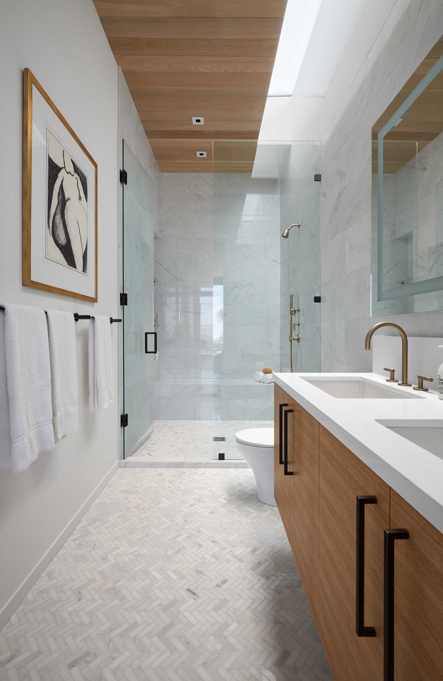 A modern bathroom with wood accents and light colored tiles.