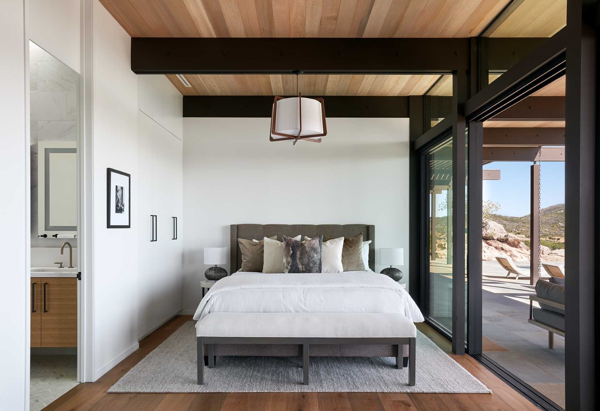 A modern bedroom with exposed beams.