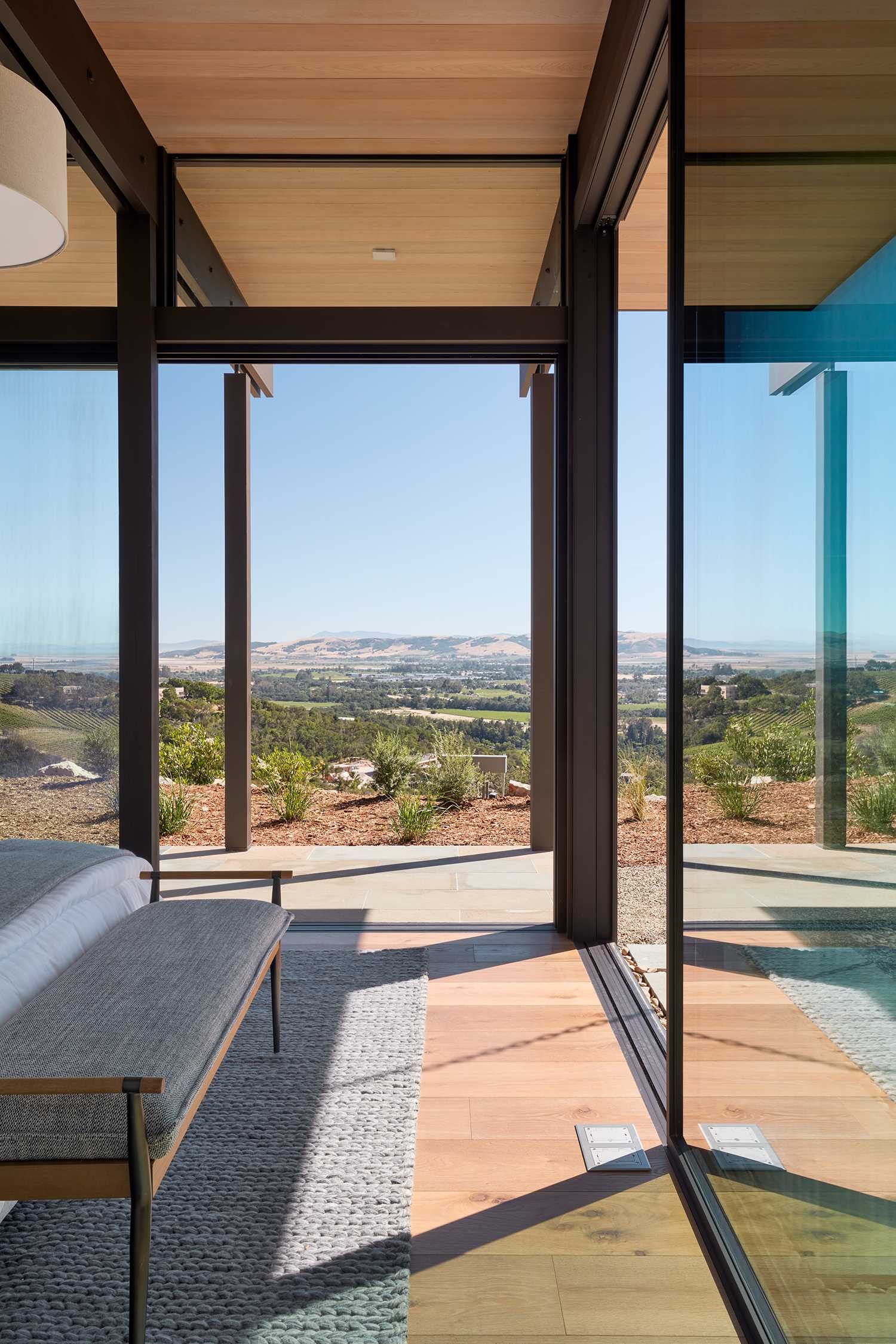 A modern bedroom has sliding glass doors that open to the outdoors.