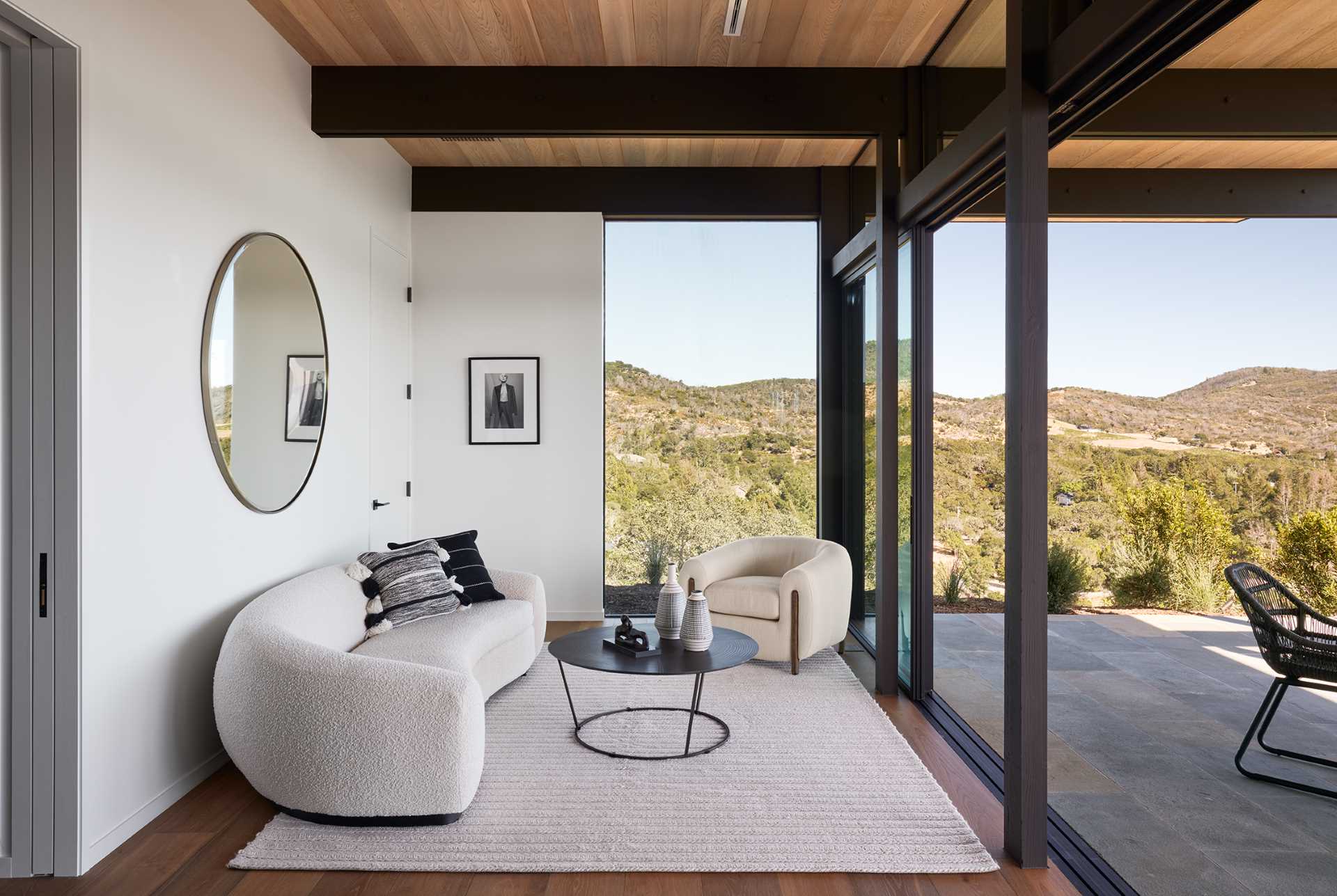 A modern living room with a curved boucle couch and sliding glass doors that open to a patio.