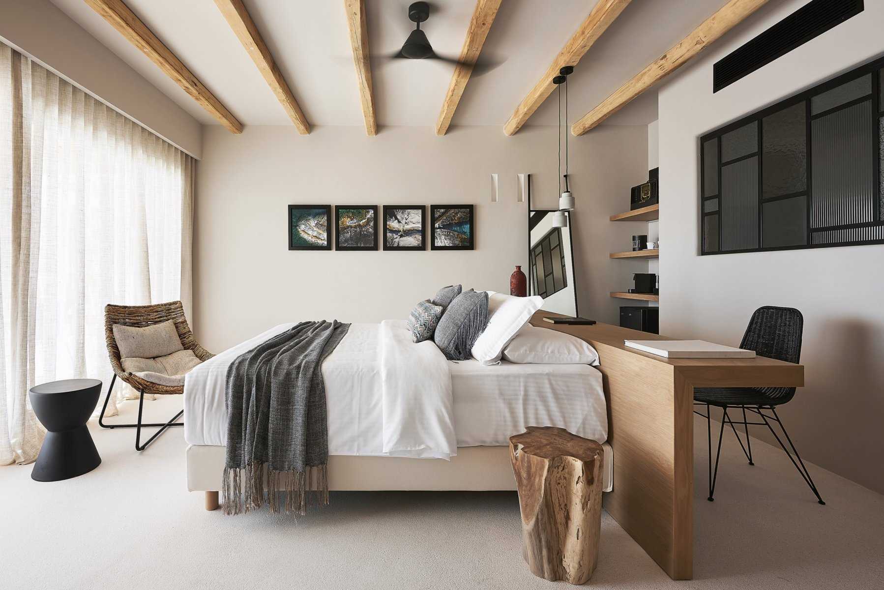 A modern hotel room has a headboard that extends to become a desk.