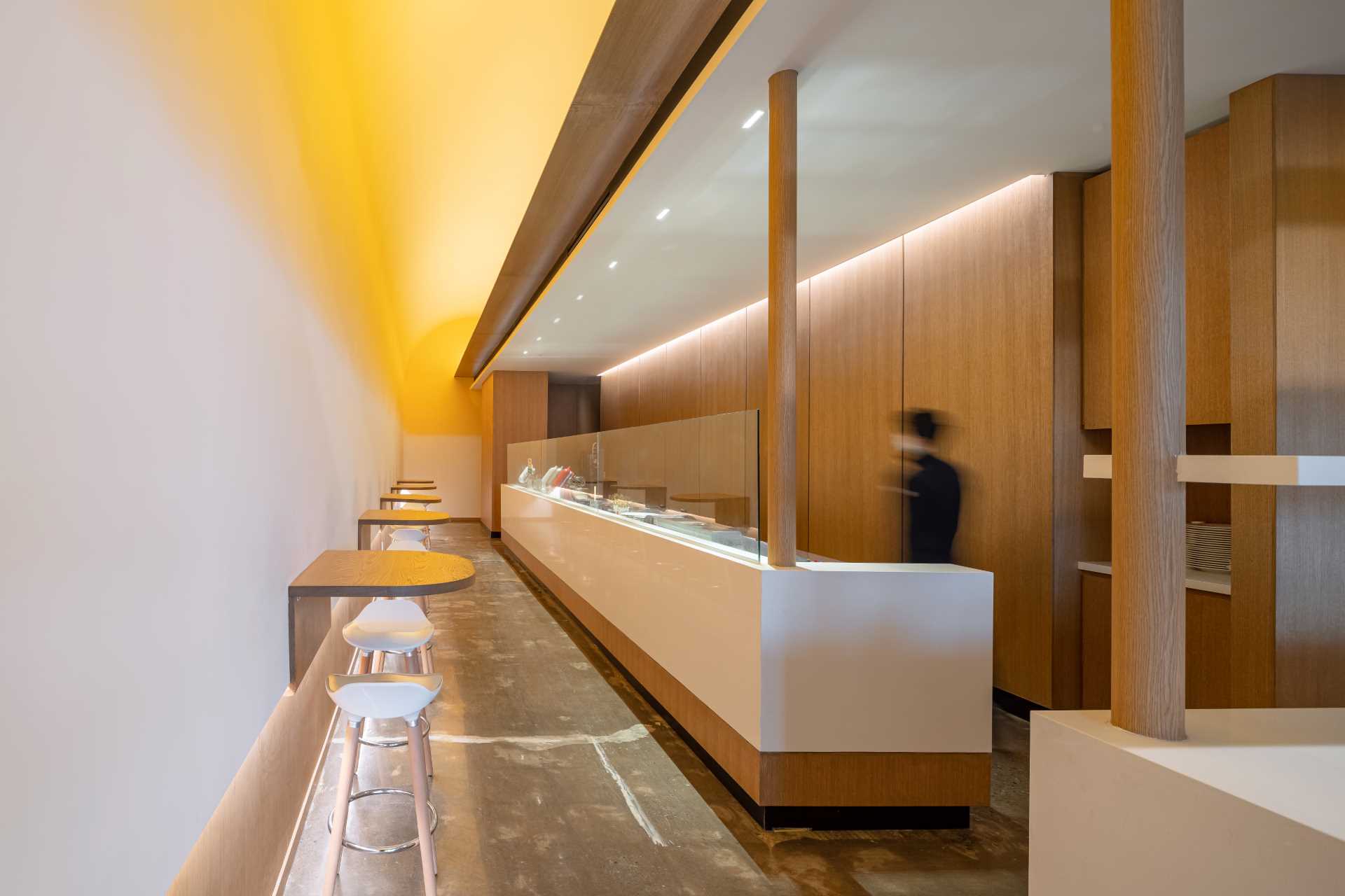 A modern cafe with an exposed kitchen and minimalist serving area.
