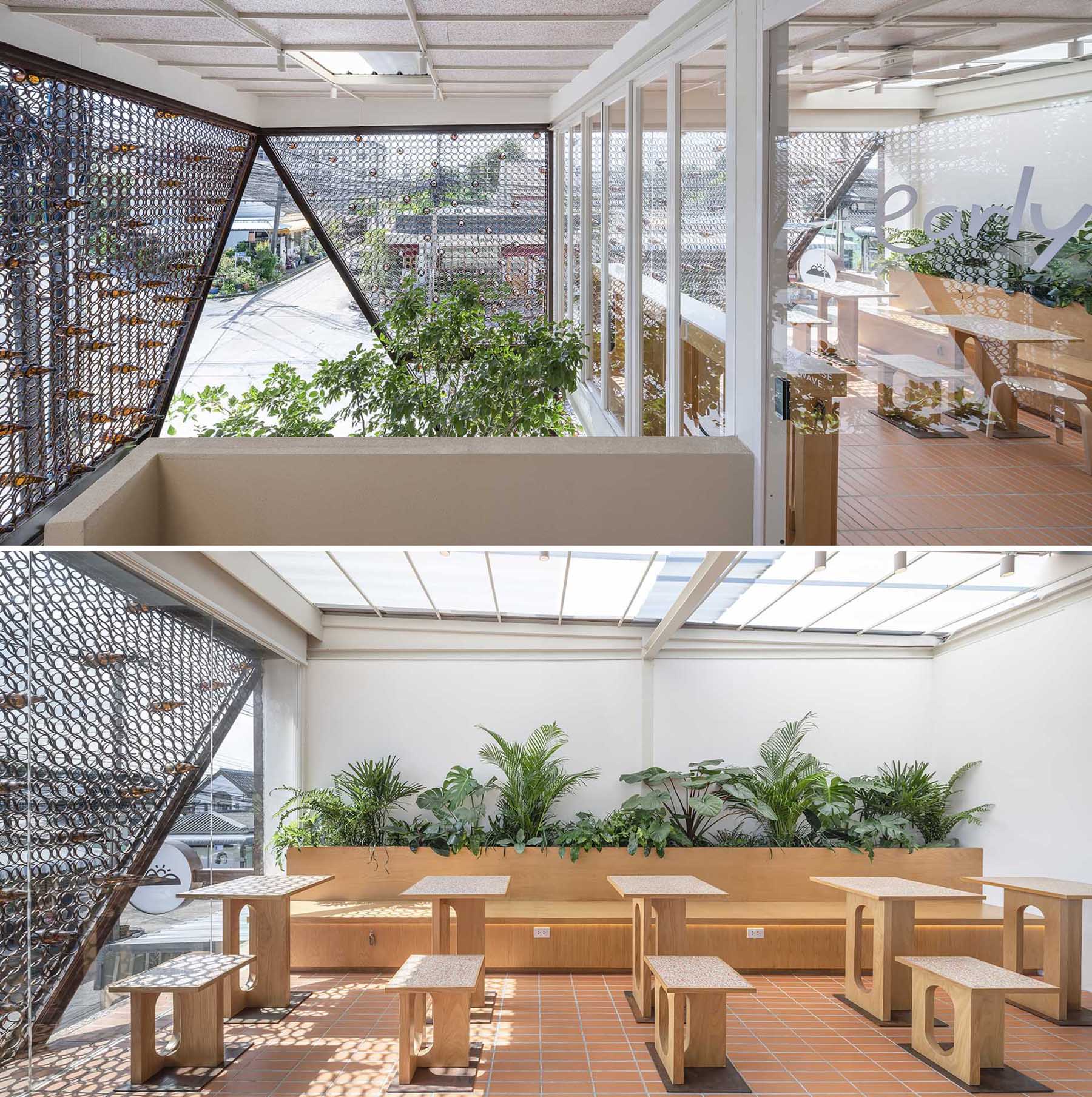 A modern cafe with wood seating and tables, and built-in planters.