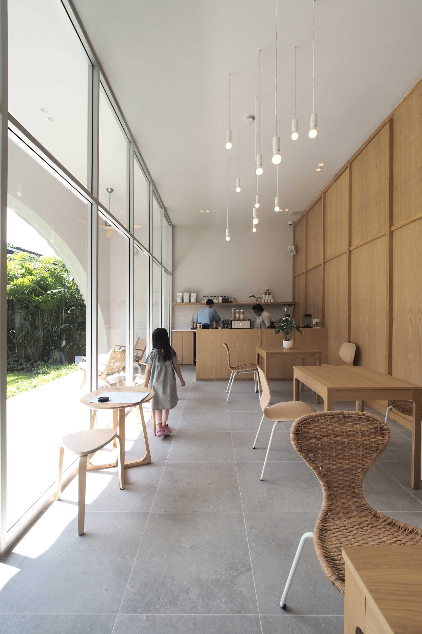 A modern cafe with a wall of glass and a small patio.