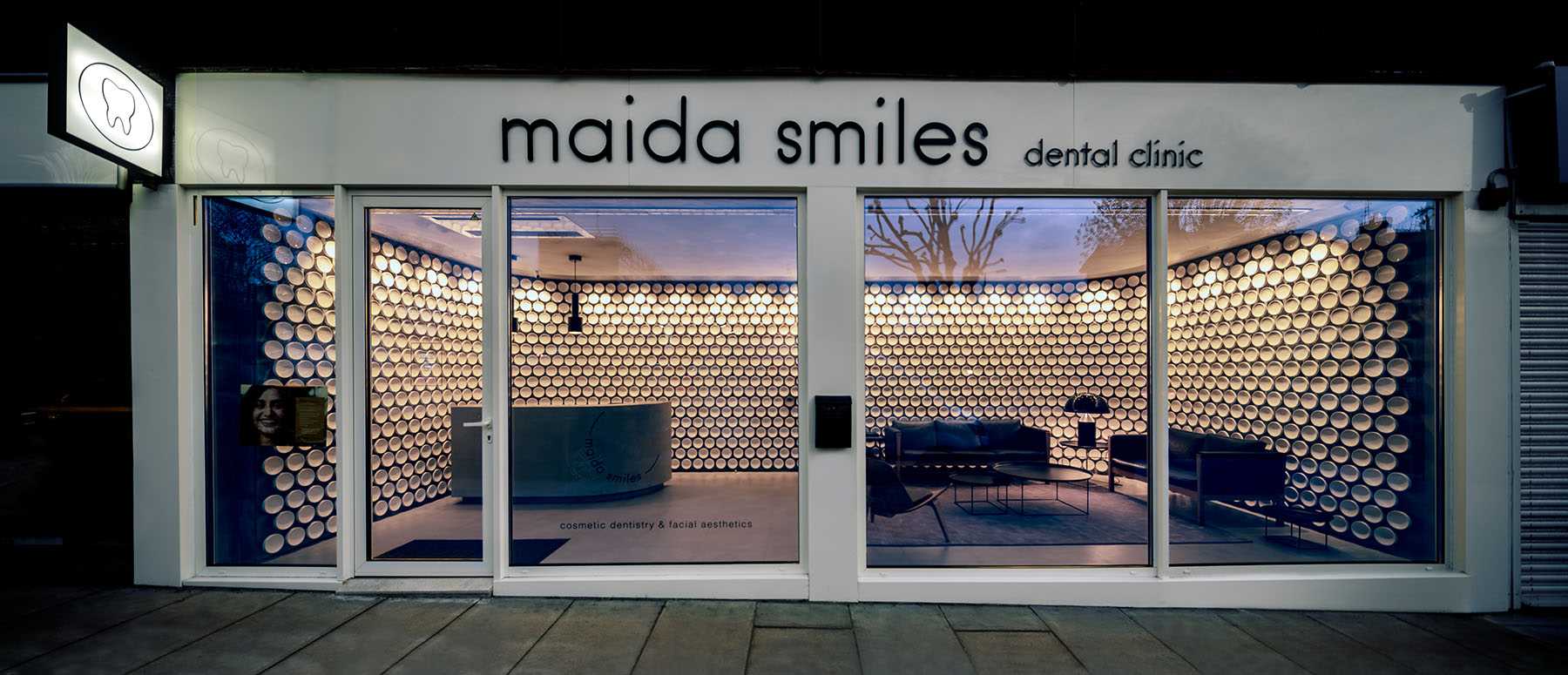 More than 500 hand-crafted ceramic discs line the wall of this modern dental clinic, while microcement covers the floor.