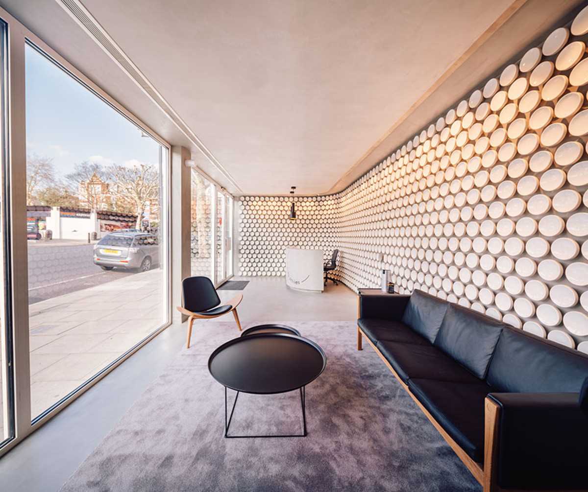 More than 500 hand-crafted ceramic discs line the wall of this modern dental clinic, while microcement covers the floor.