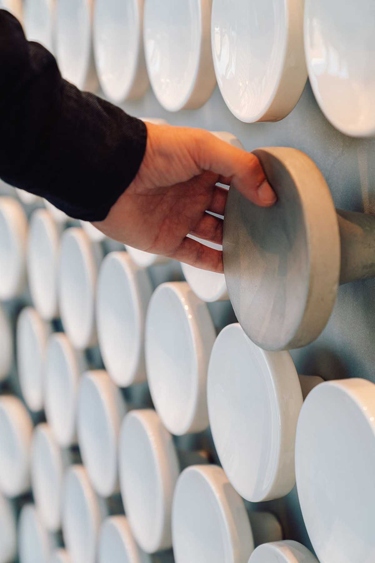 A grey ceramic disc acts as a handle for a hidden door.