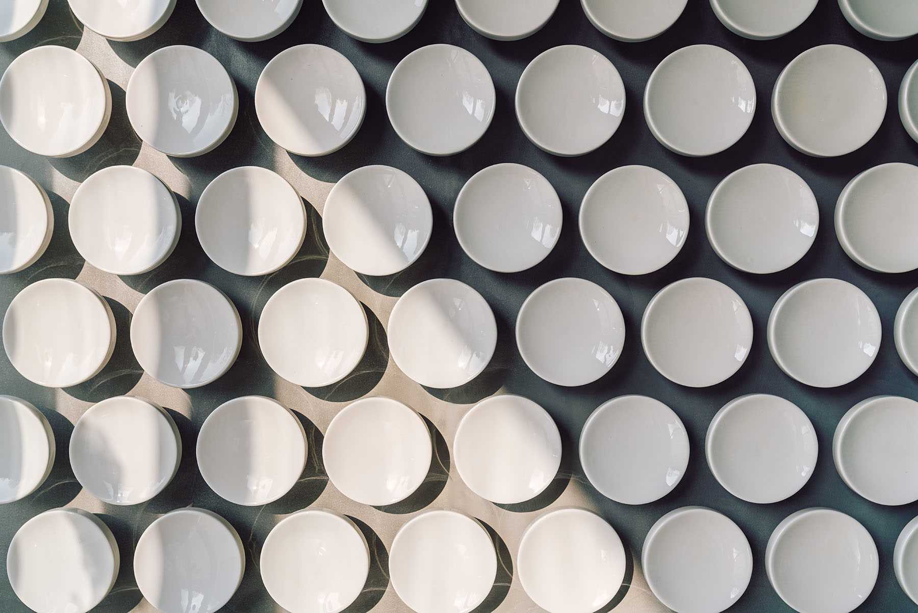 Mais de 500 discos de cerâmica feitos à mão revestem a parede desta moderna clínica odontológica.