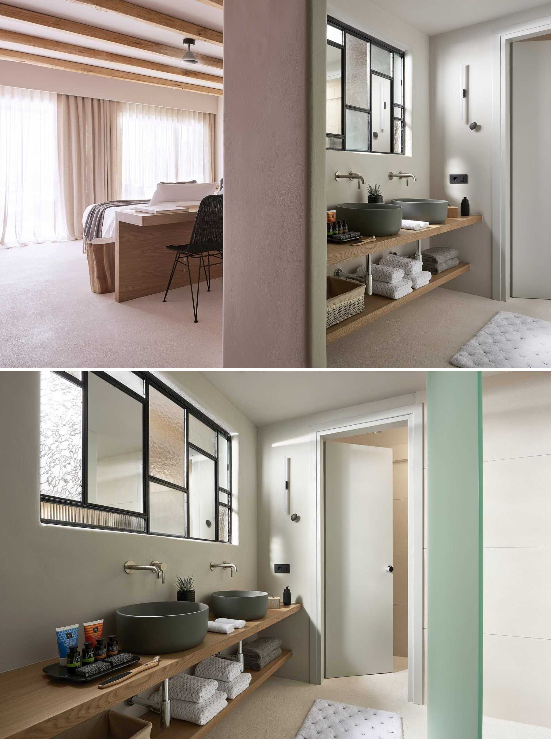 This modern hotel room has an interior window, with mirrors included as part of the window frame, that allows natural light to flow throughout the space, while the wood vanity complements the bed headboard and desk.