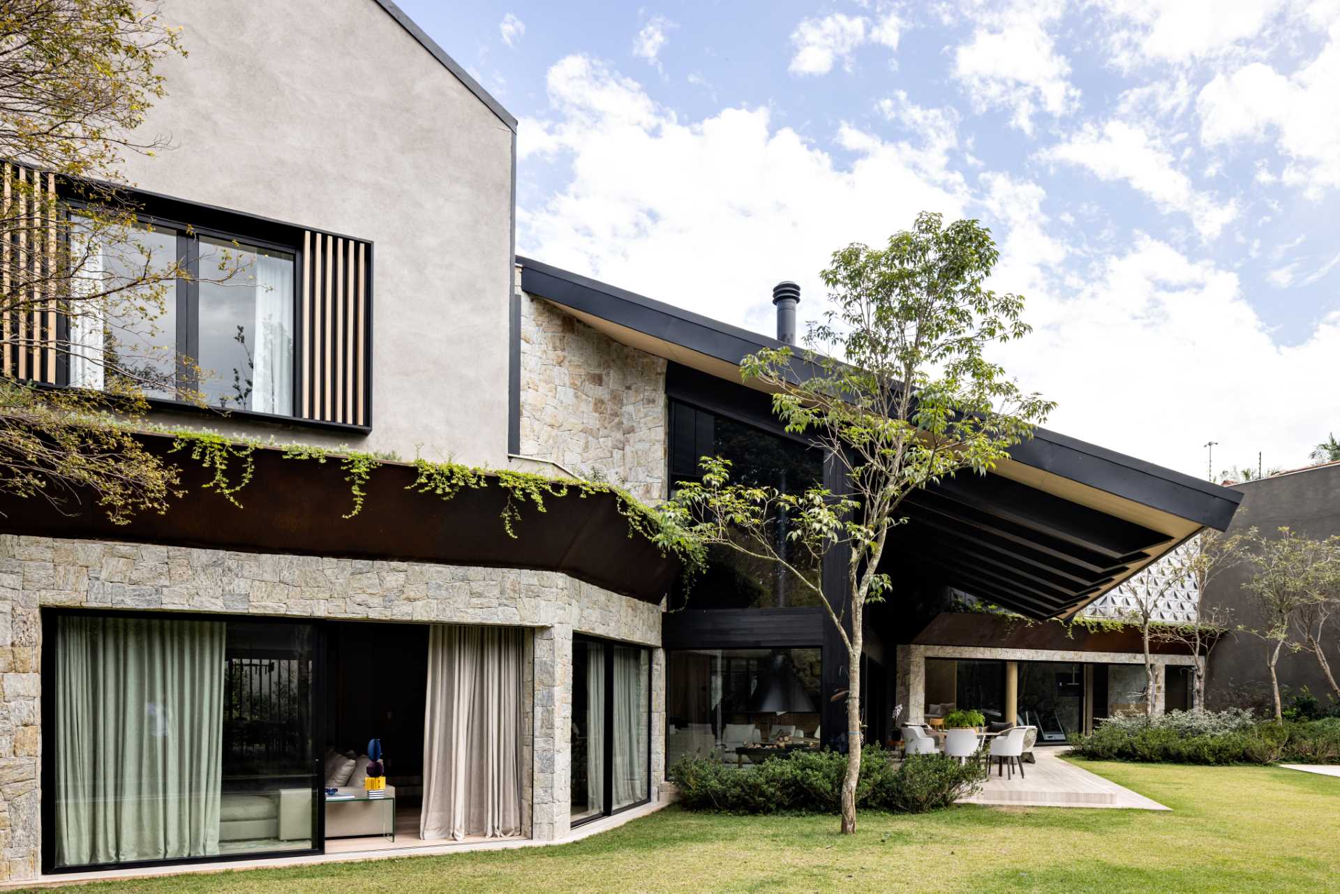 A remodeled home includes a large roof that overhangs a patio.