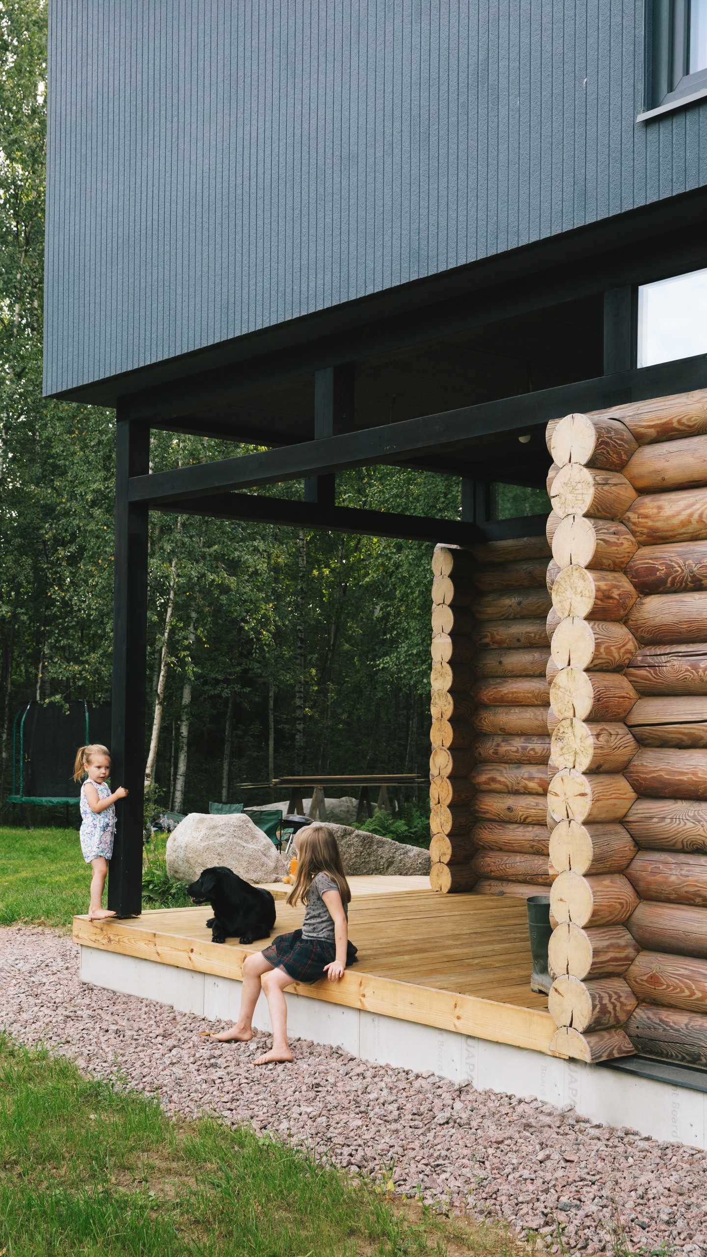 A modern log home with a modern black second floor.