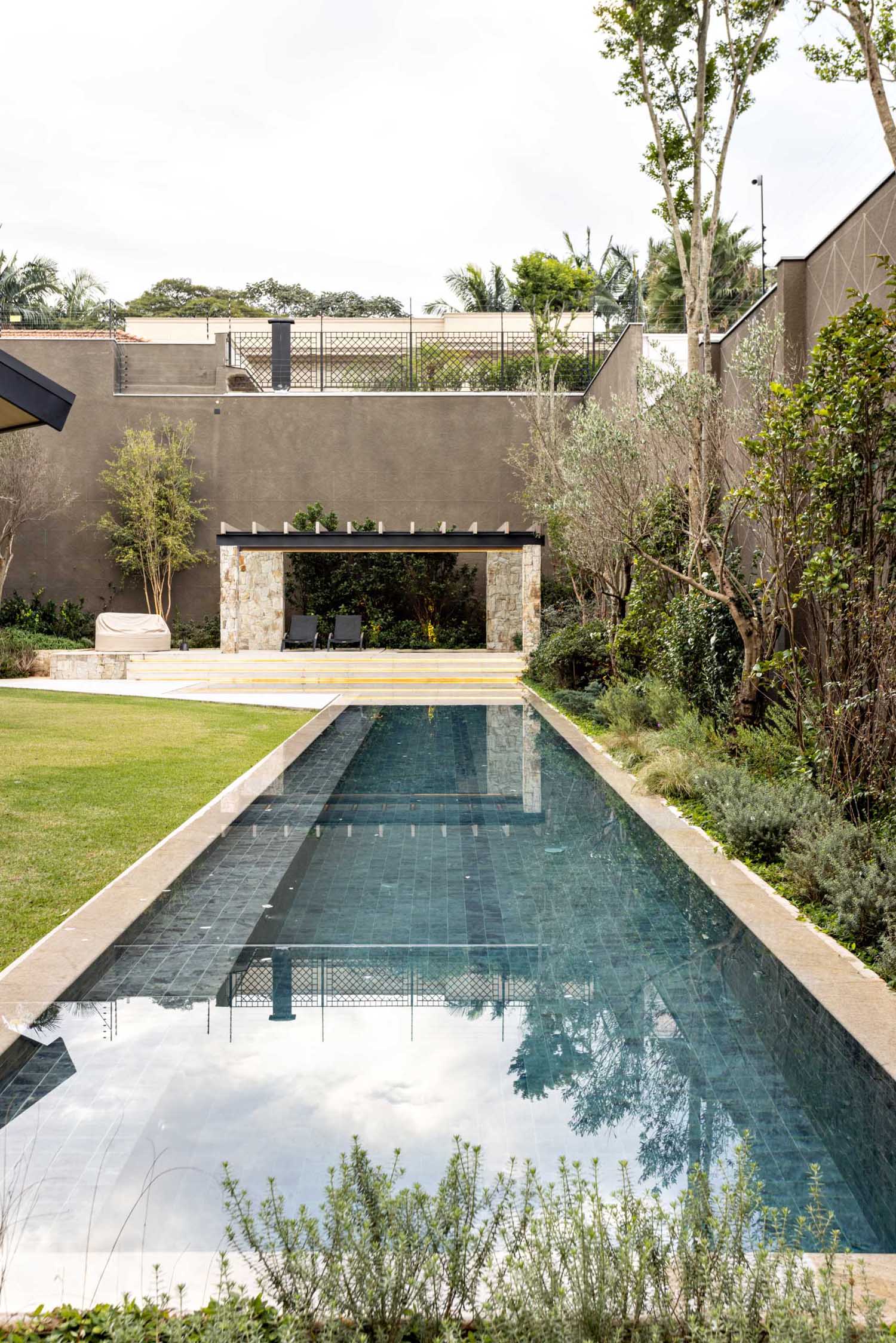 A modern house with a long swimming pool and cabana.
