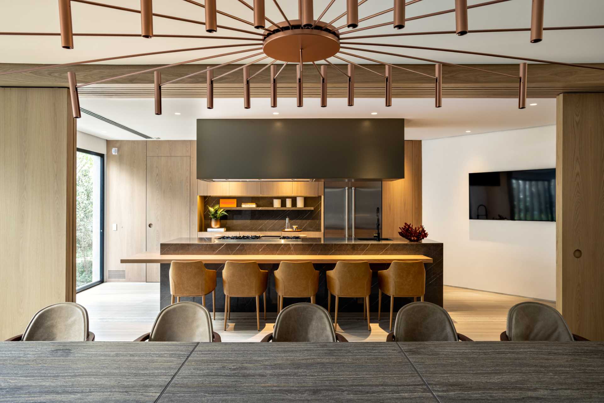 Sliding wood doors separate the formal dining room from the kitchen. In the kitchen there's a large island with a lower wood countertop that people can sit at.