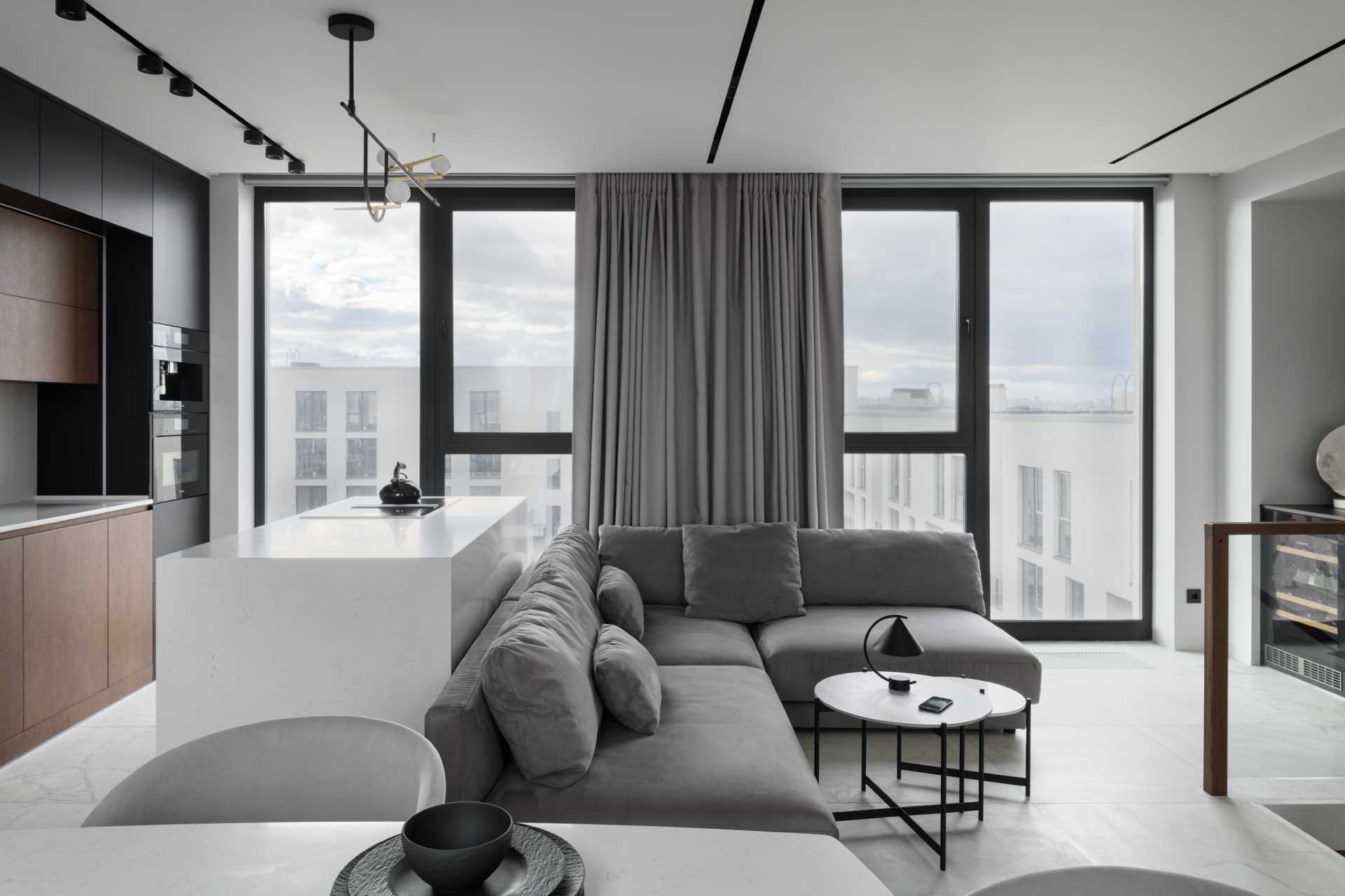 A modern apartment with a wood, white, black, and grey color palette.