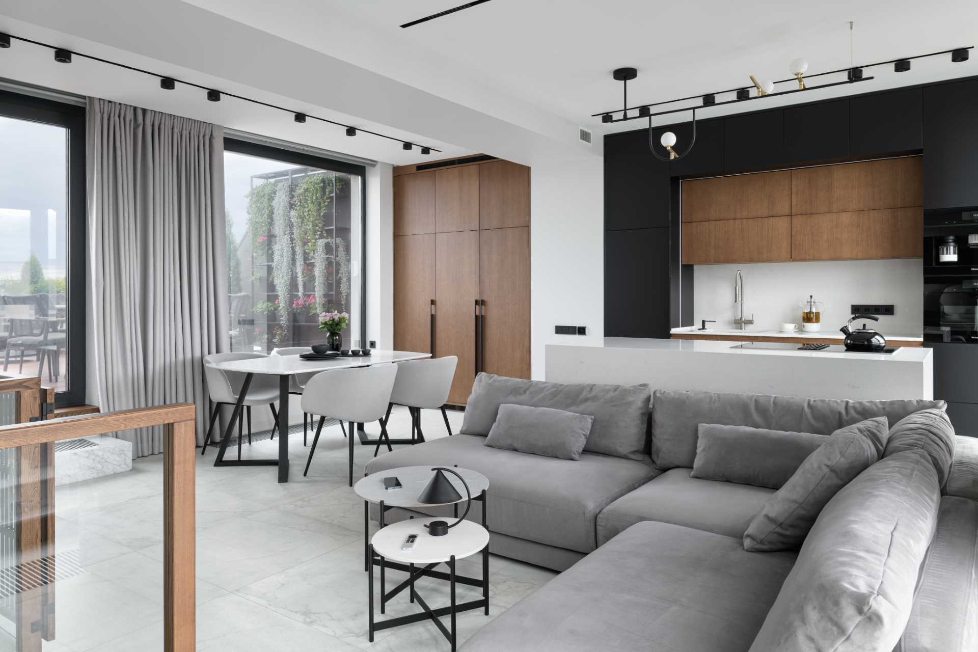 A modern apartment with a wood, white, black, and grey color palette.