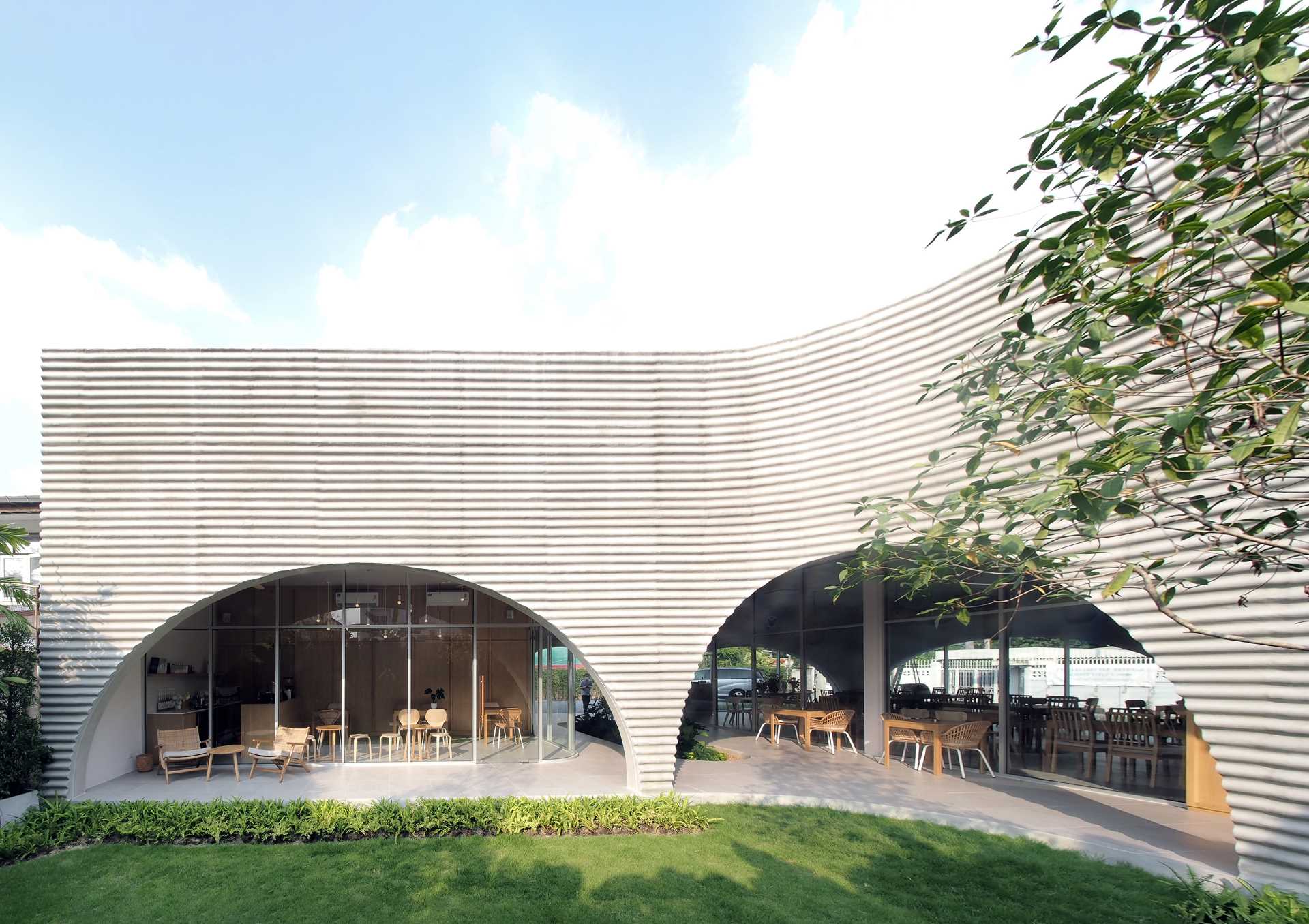 A modern cafe and restaurant with a covered patio and garden, and arched details.