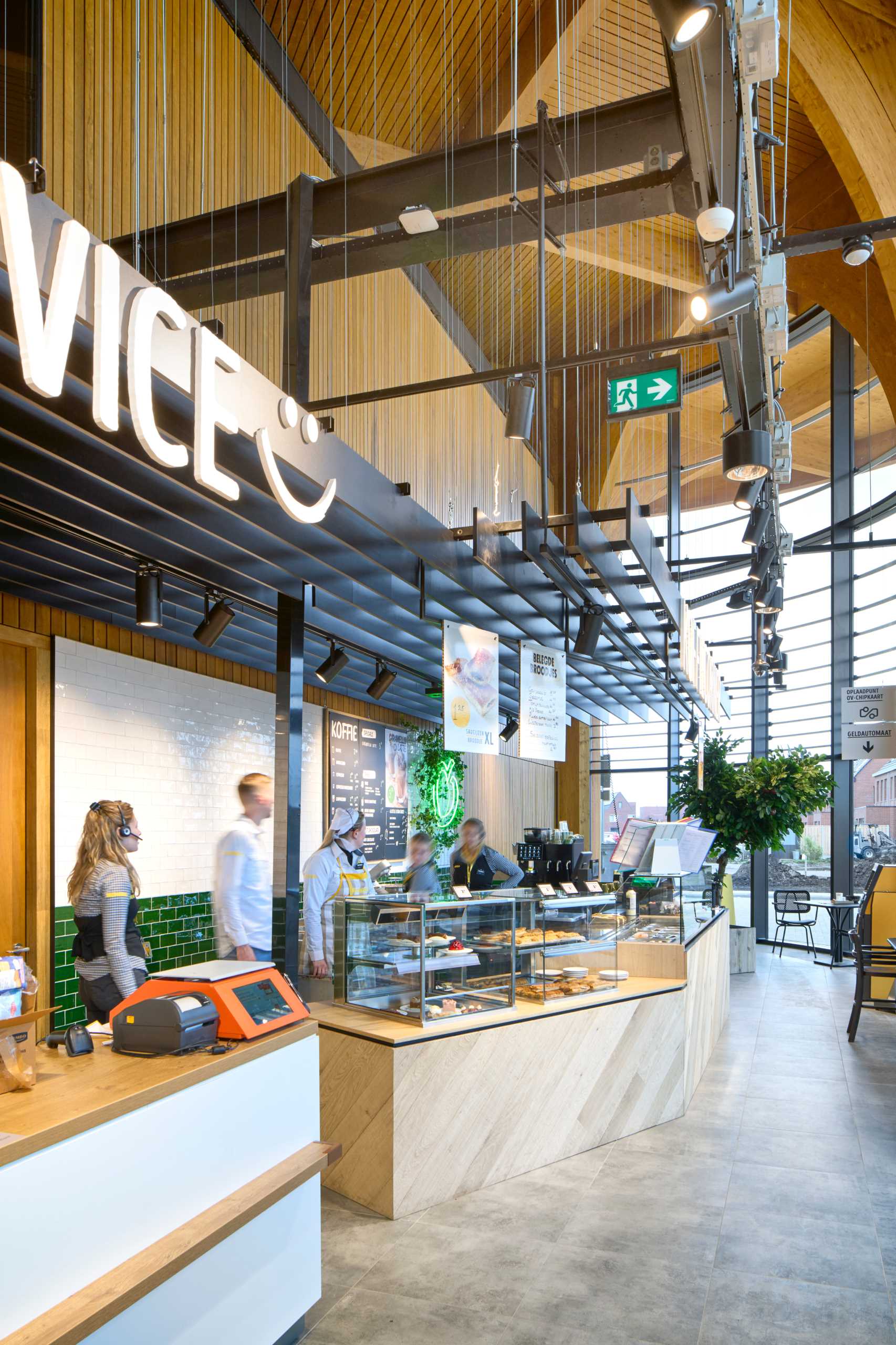 A modern supermarket and cafe with an exposed wood structure with a cathedral-like appearance.