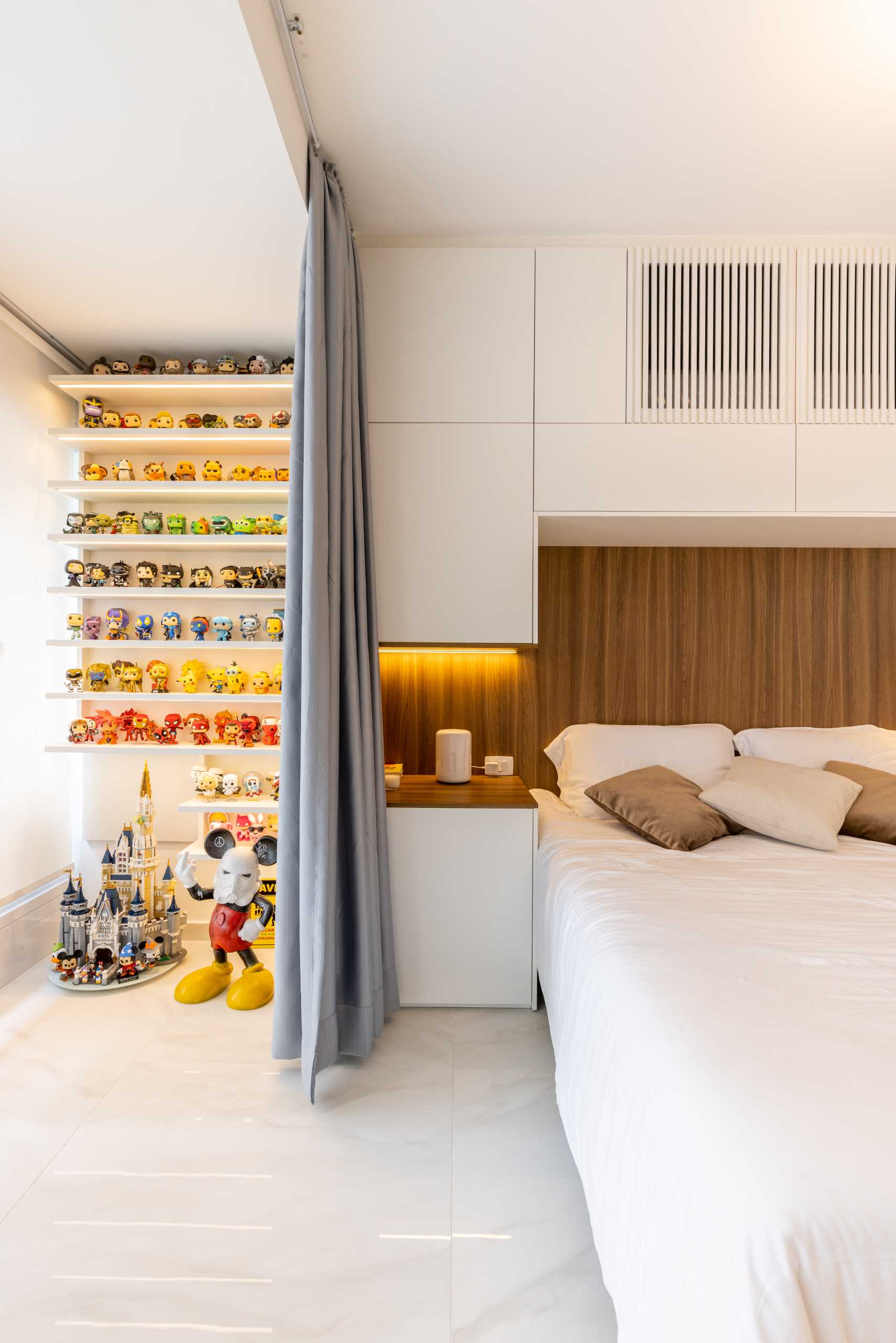 یک اتاق خواب مدرن با طرح باز با پرده برای دیوارها، انباری، تخته سر چوبی و نور مخفی.