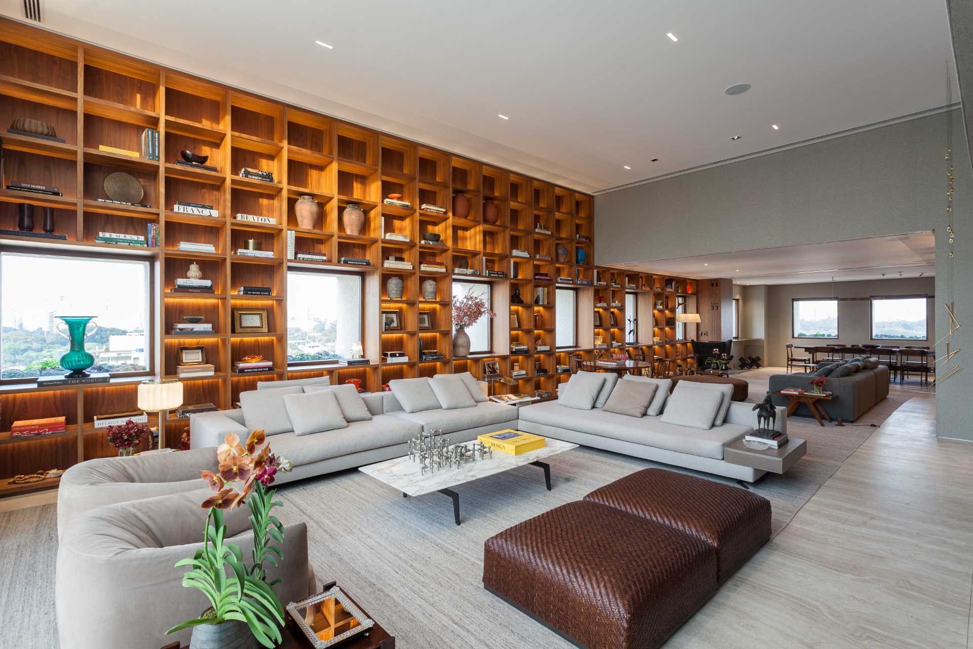 The design of this bookshelf allows the focus to be on the multiple windows that also share the wall, with the shelves framing the windows as if they were paintings.