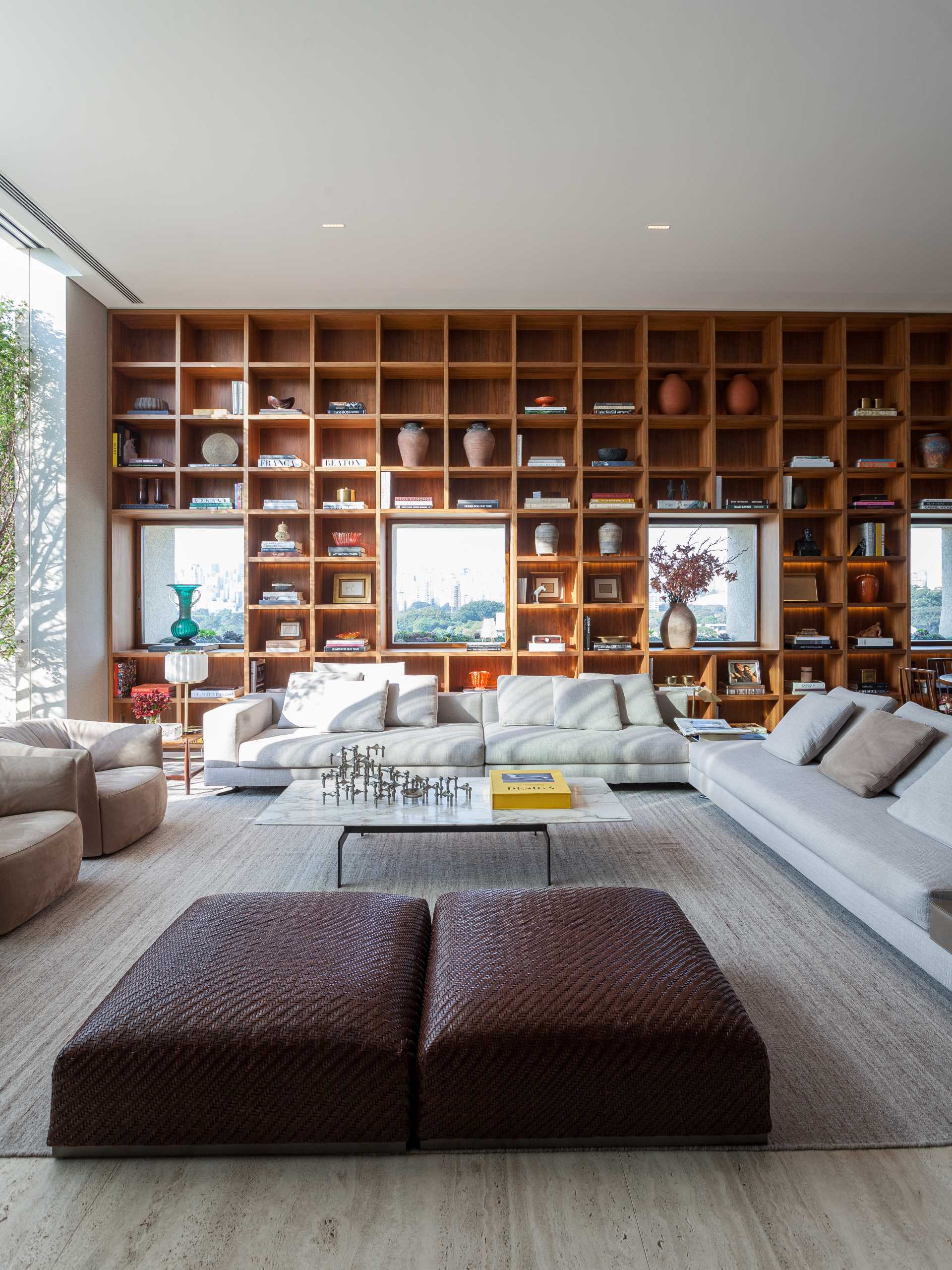 The design of this bookshelf allows the focus to be on the multiple windows that also share the wall, with the shelves framing the windows as if they were paintings.