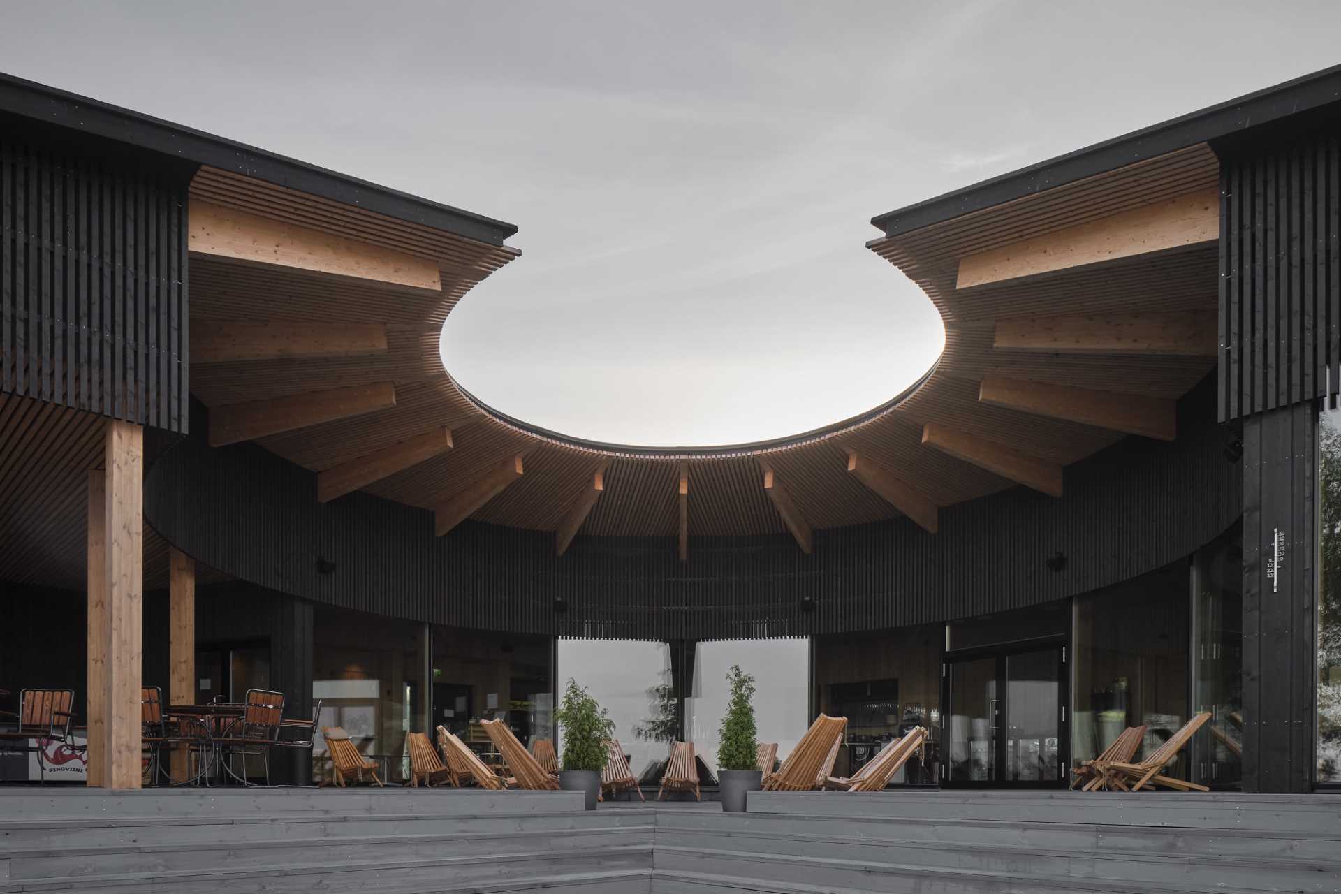 This new lakeside sauna and restaurant boast a strong design aesthetic based on a central, curved outdoor space with the restaurant and sauna spaces spiraling around it.