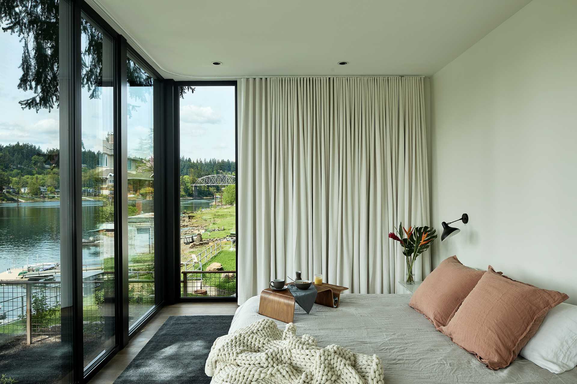 A modern bedroom with floor-to-ceiling windows.