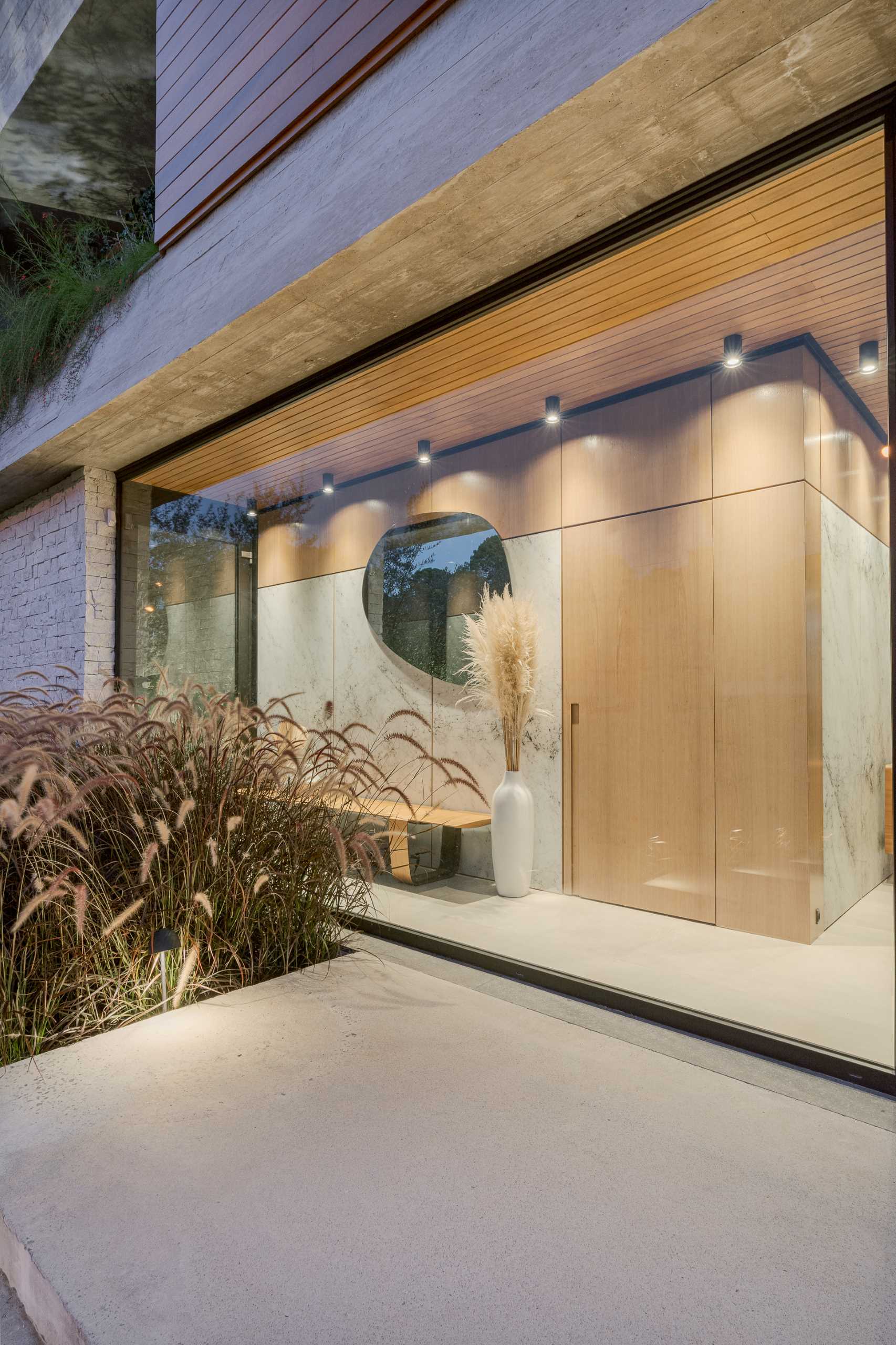 یک ورودی مدرن با پنجره های از کف تا سقف و یک نیمکت، دسترسی به اتاق پودر را فراهم می کند.