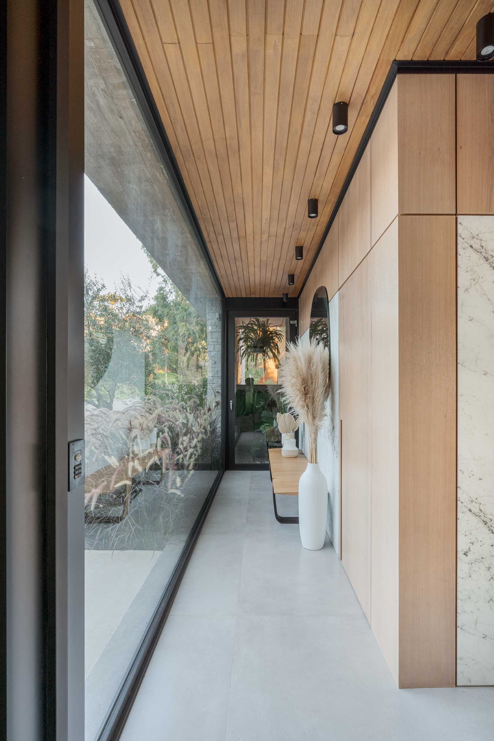 A modern entryway with a bench provides access to a powder room.