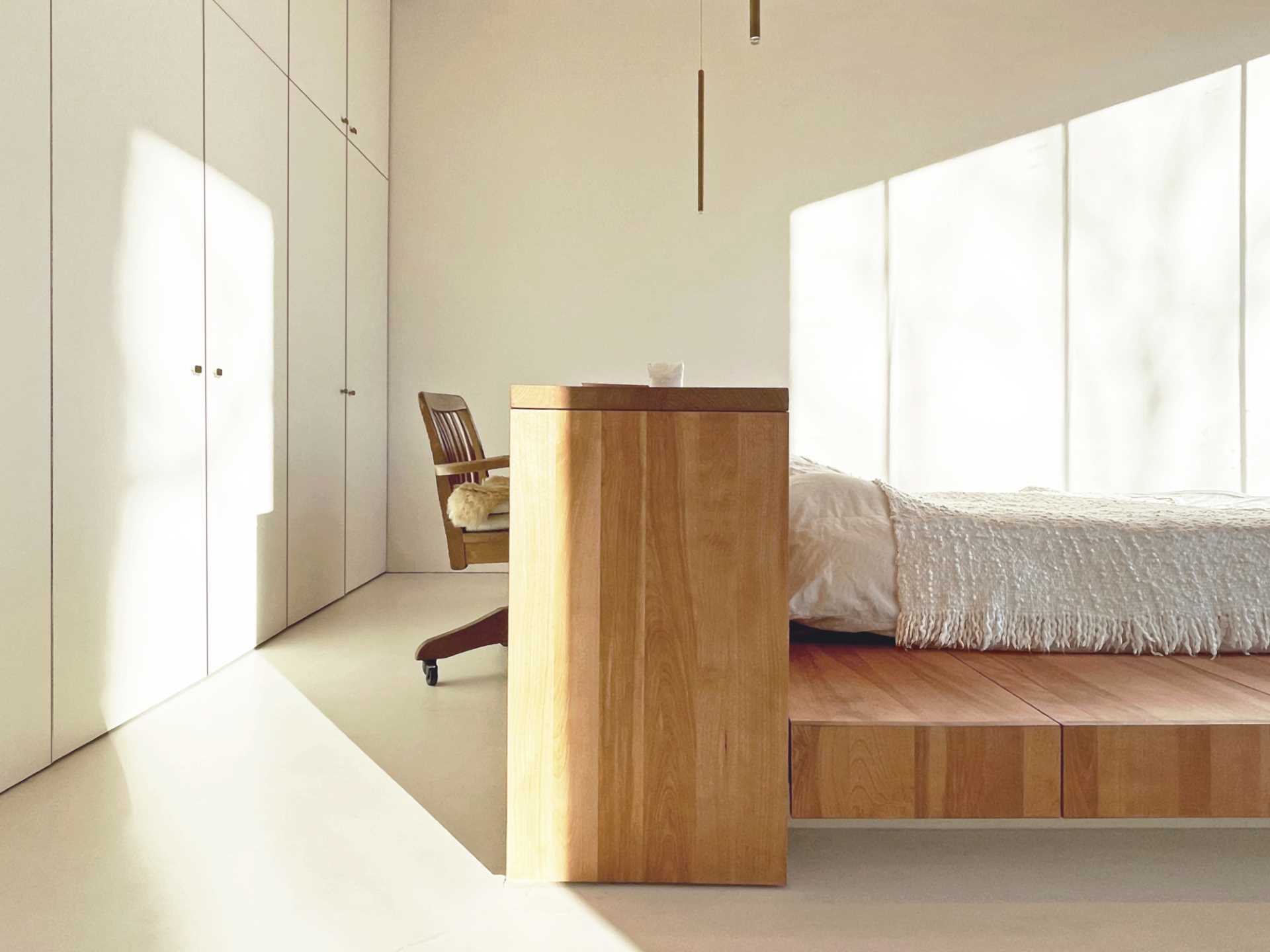 A modern bedroom with a bed frame that includes a desk built into the headboard.