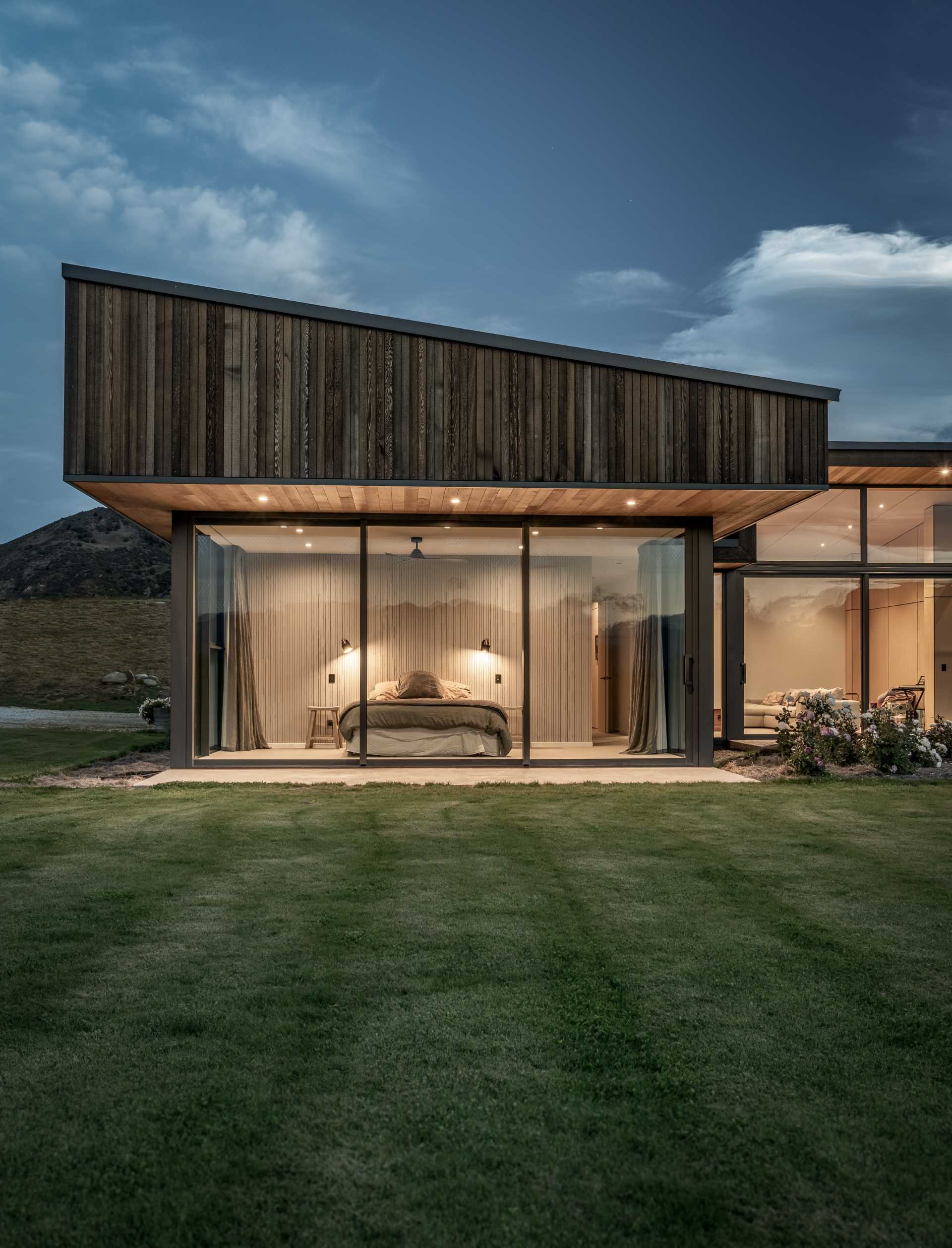 Rooflines on the outer wings slope towards the centre of this modern home, giving the building a contemporary aesthetic, which is furthered by robust overhangs.