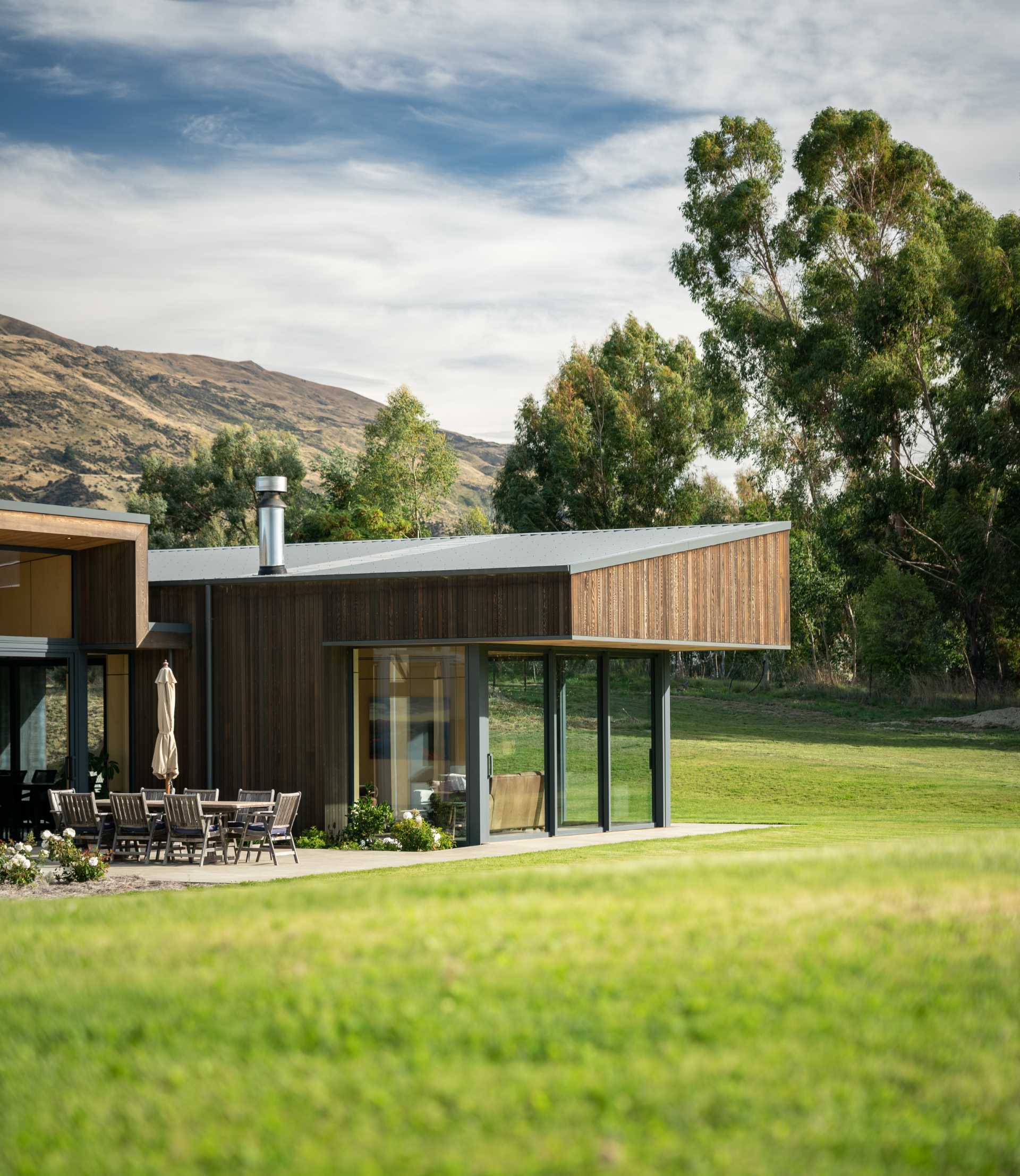 Rooflines on the outer wings slope towards the centre of this modern home, giving the building a contemporary aesthetic, which is furthered by robust overhangs.