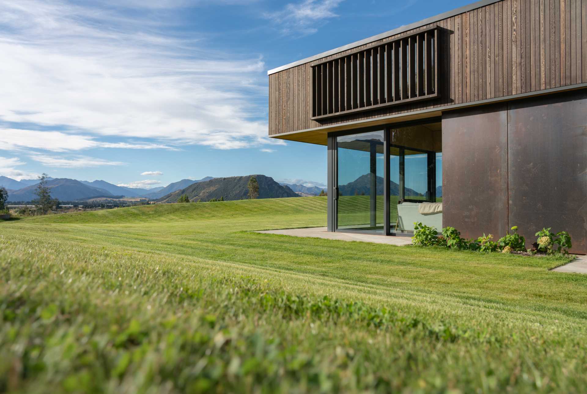 Slatted upper windows shield this modern home from high summer rays while still allowing light through.