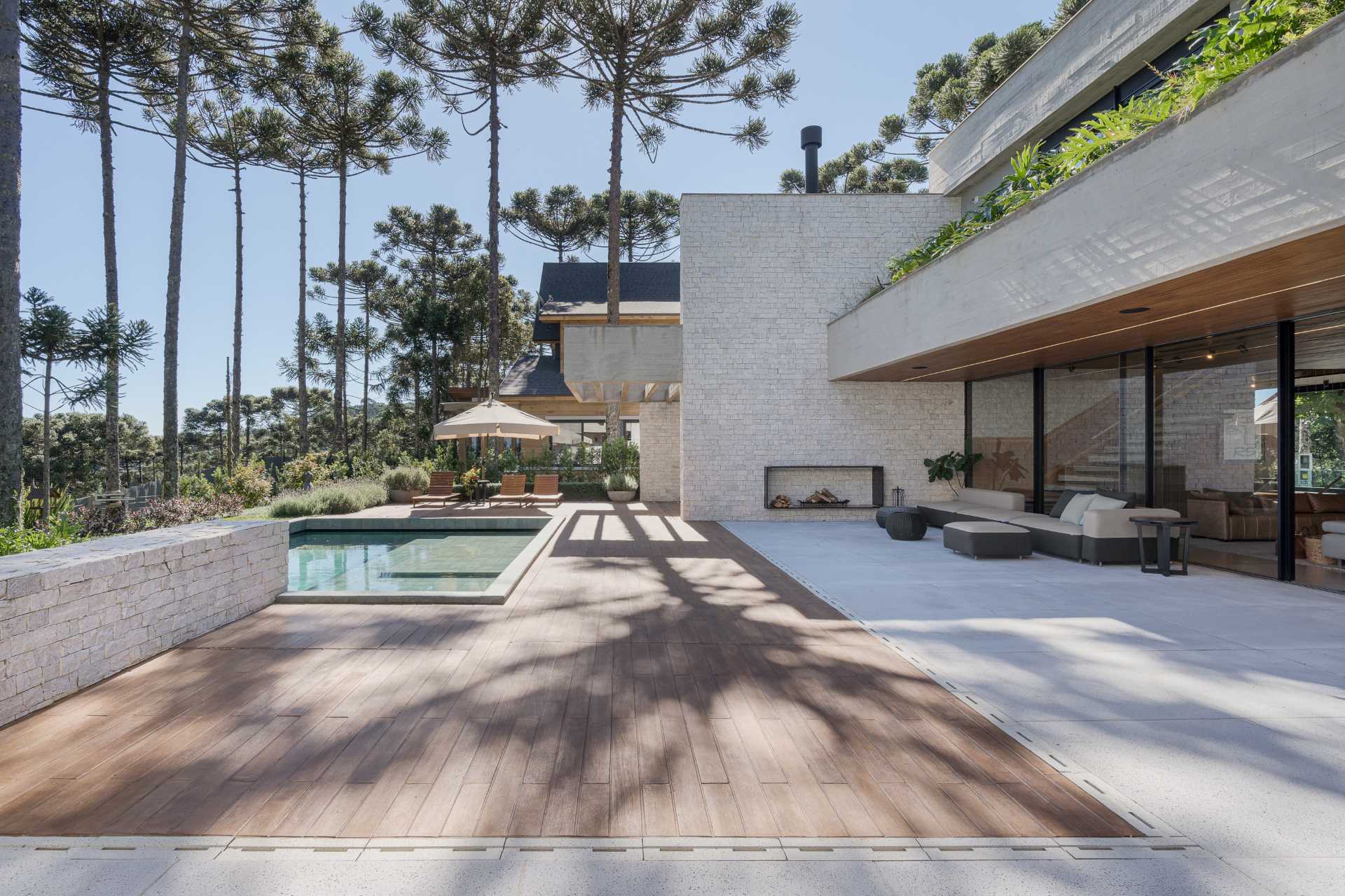 A modern home with a swimming pool, patio, and wood deck.