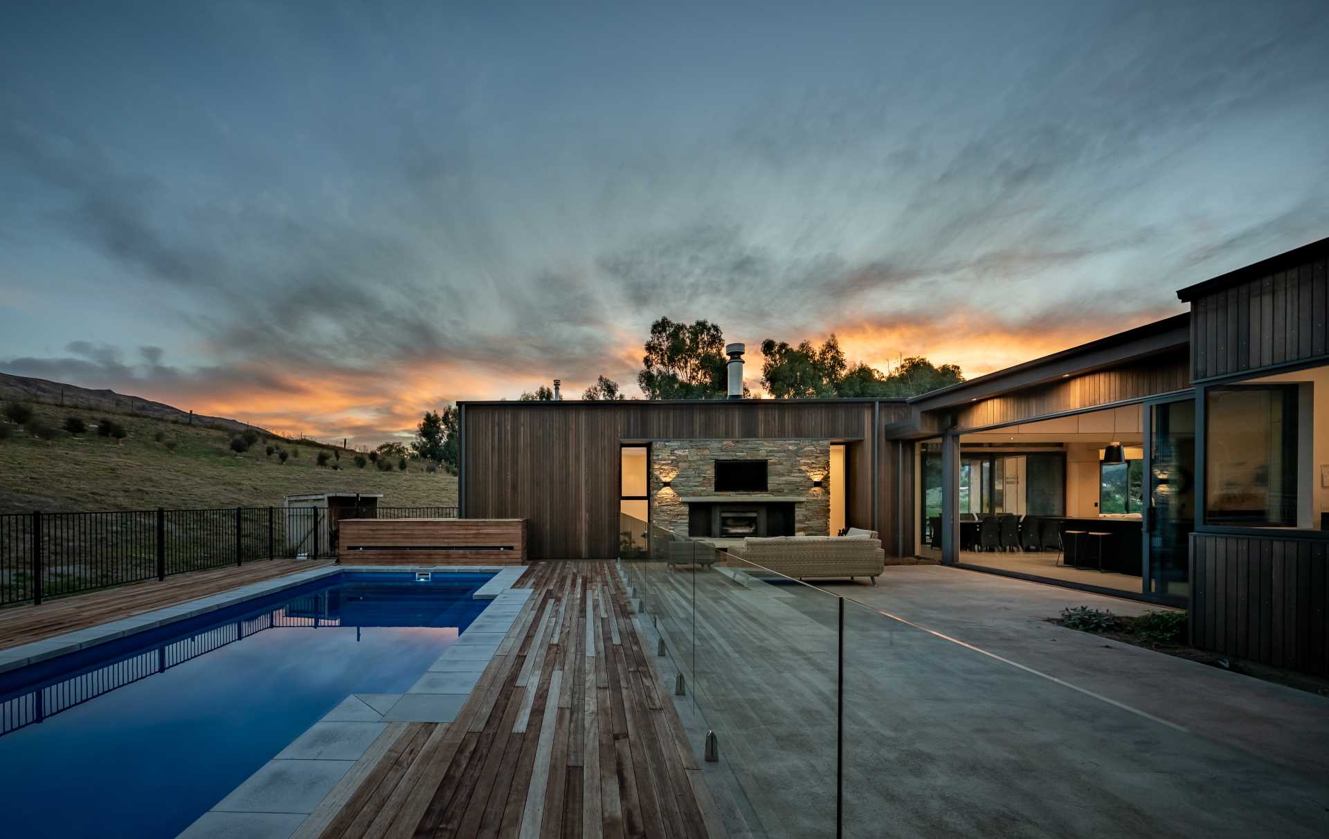 A modern house with a sheltered patio and swimming pool.