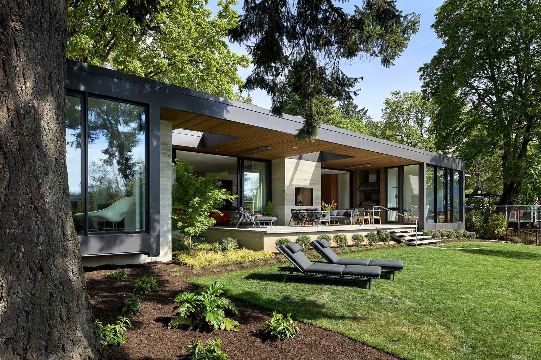 A modern house with a partially covered patio with a wood burning fireplace.