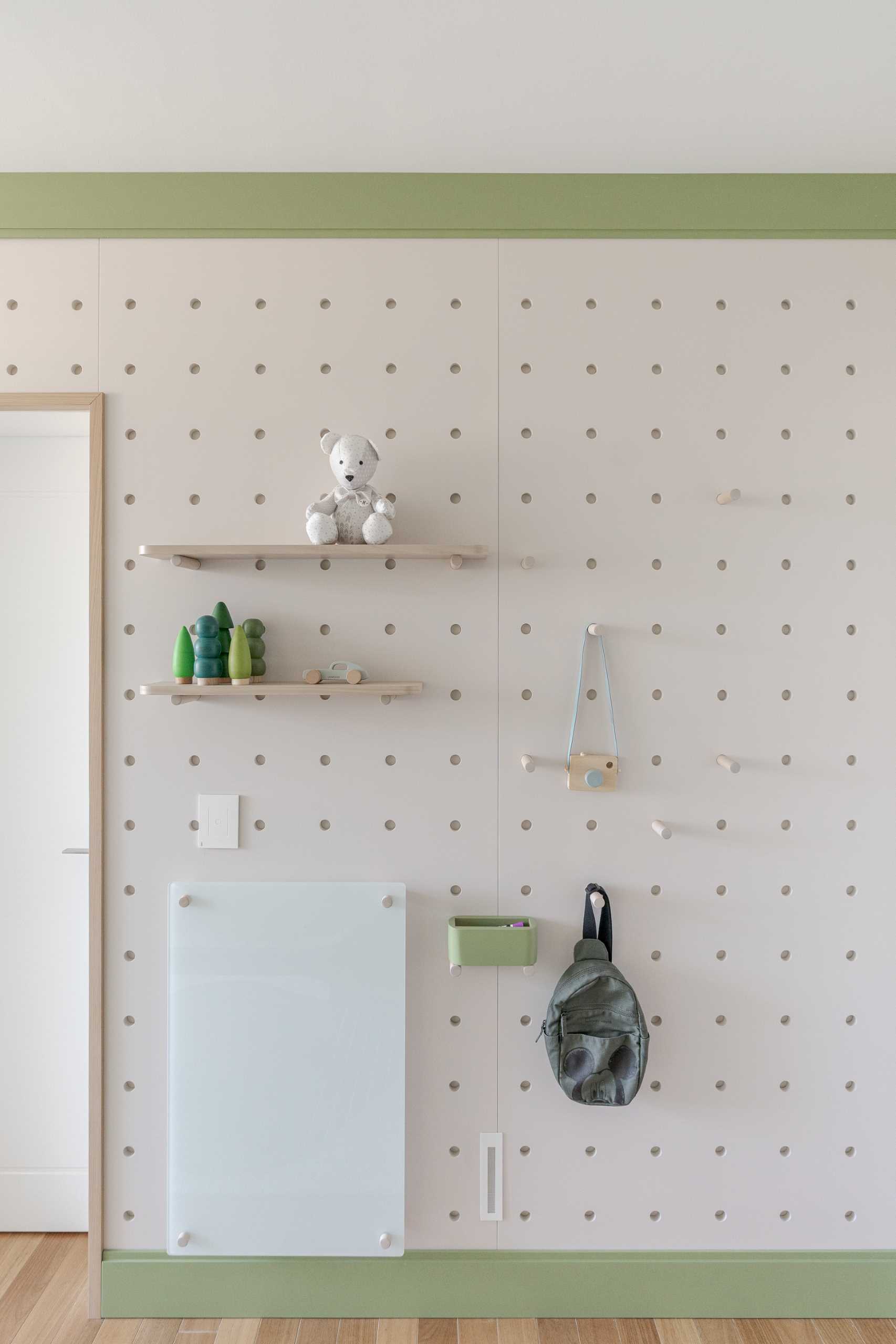 A modern kids room with a pegboard storage and display wall.