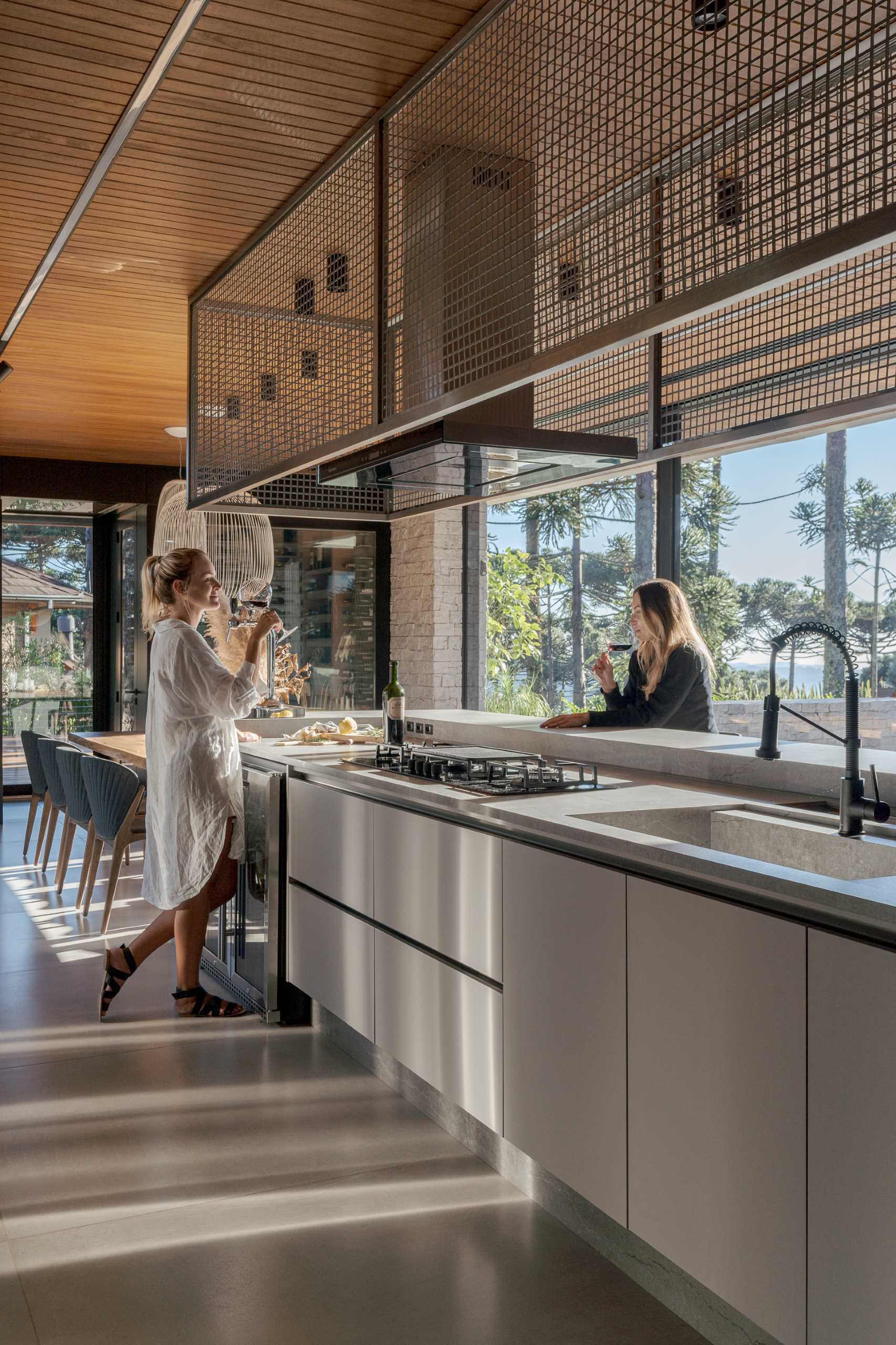 A modern kitchen with a long island that transitions into a dining table.