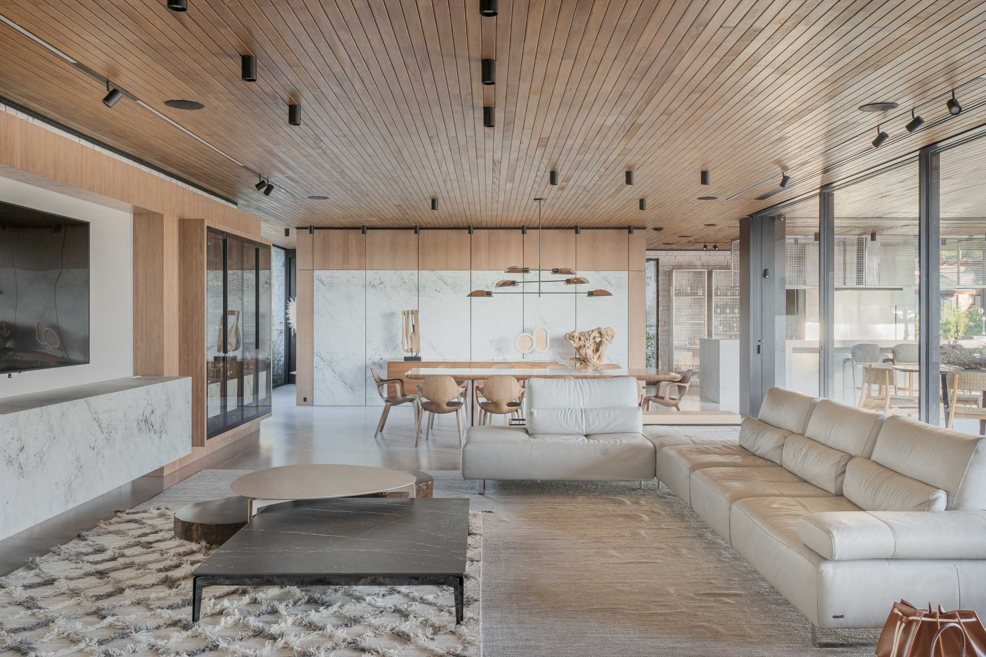 یک سقف چوبی در سرتاسر خانه به نمایش گذاشته شده است، در حالی که اتاق نشیمن شامل یک کاناپه L شکل و همچنین یک کاناپه ثانویه در کنار پله ها است.