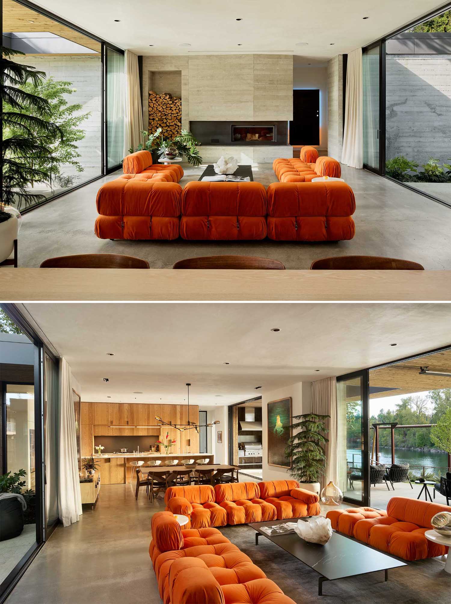 In the living room, bright orange couches face both the fireplace and the river view, as well as being open to the courtyard.