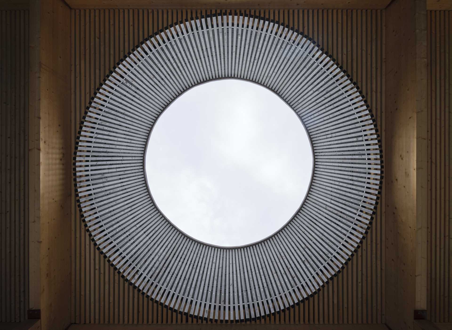 A large circle opening in the roof of a public sauna building.