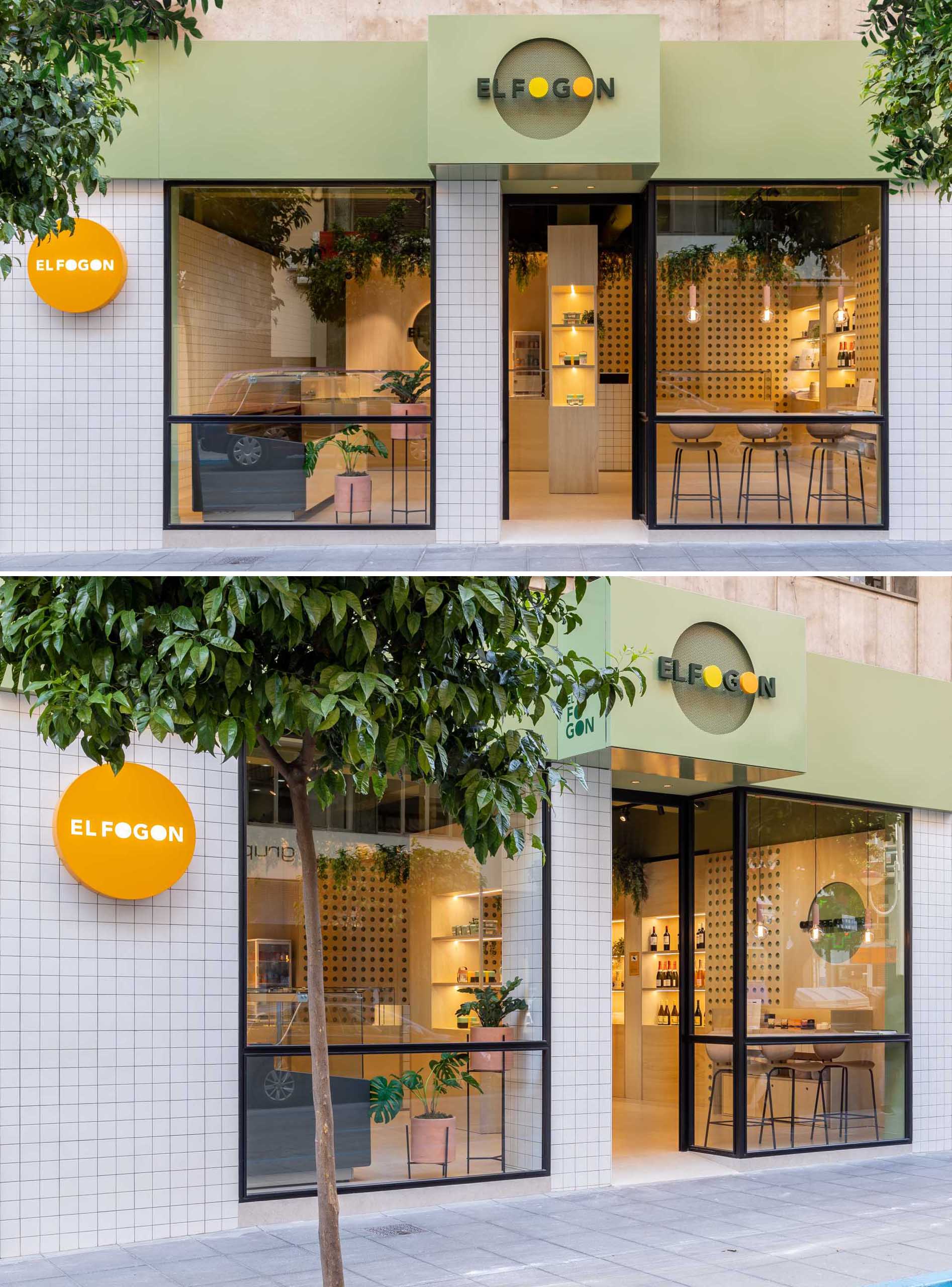 The exterior of this modern takeaway shop includes a white square tiled facade, black window frames, and a green accent above that provides a background for the logo.