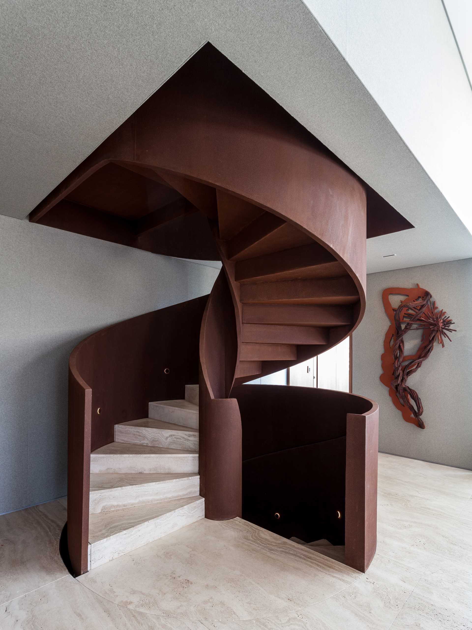 The spiral staircase, which stands out as a sculptural element in the interior, is made from Corten steel.