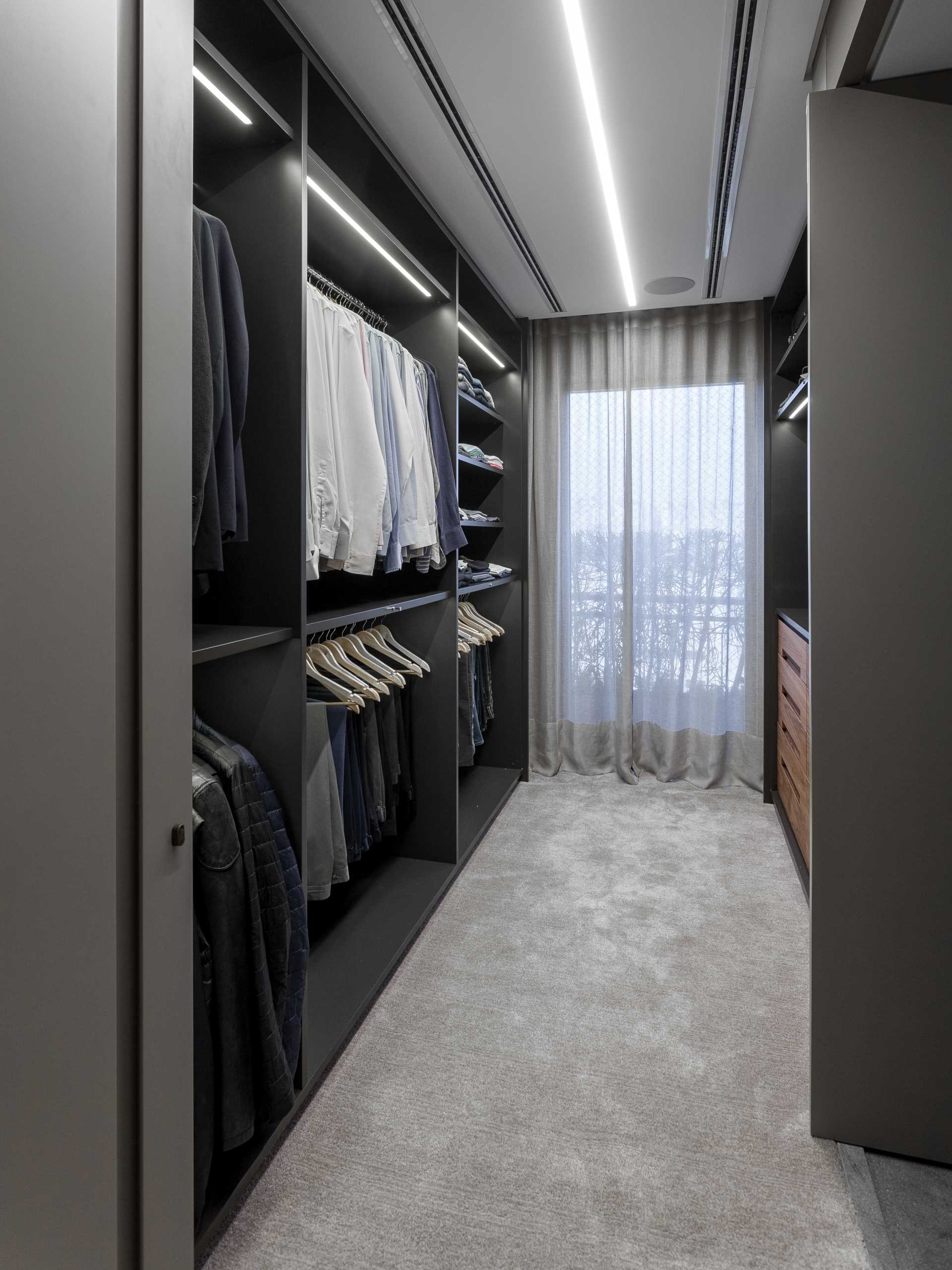 A men's walk-in closet with a built-in dresser.