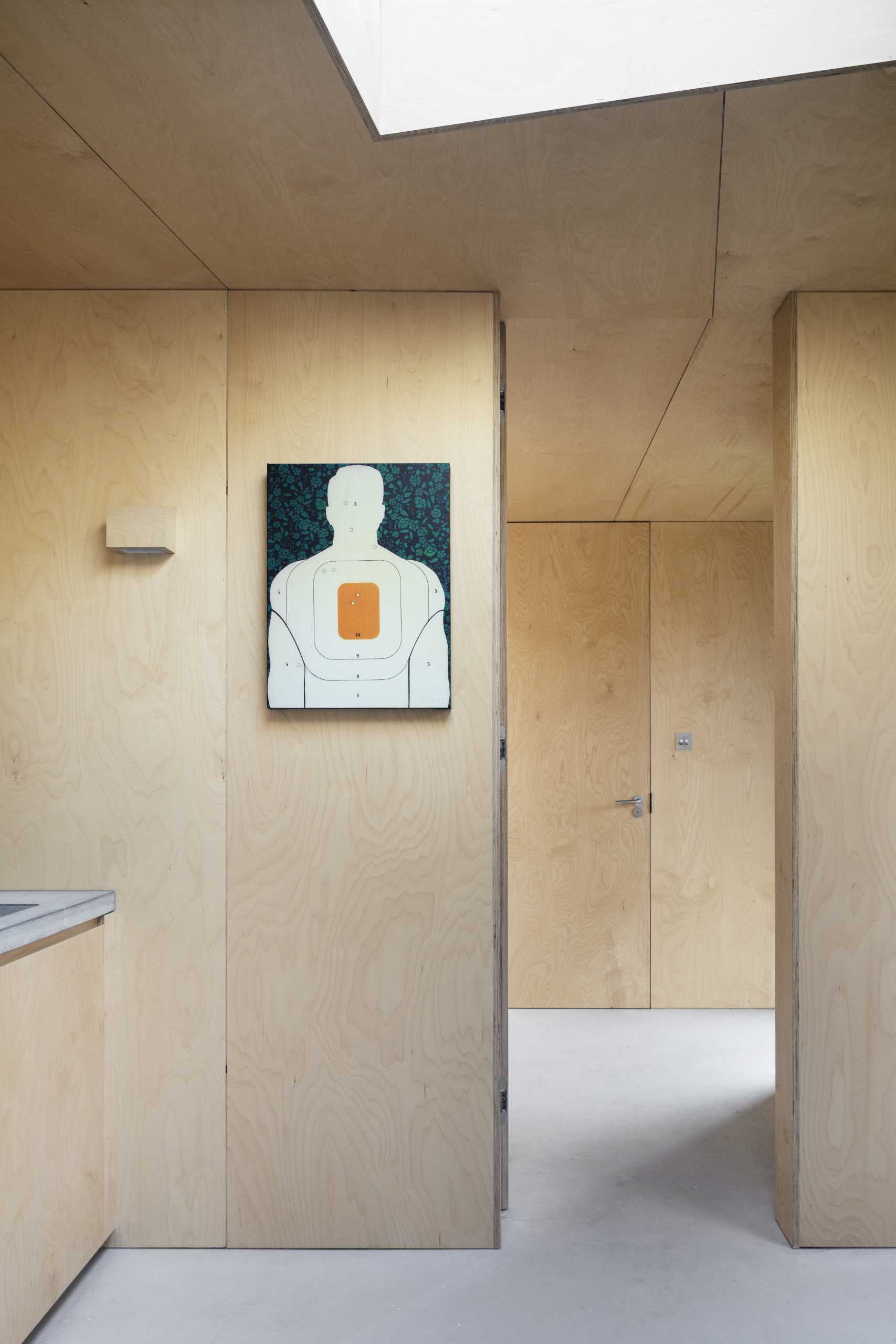 A backyard studio with plywood walls and a skylight.