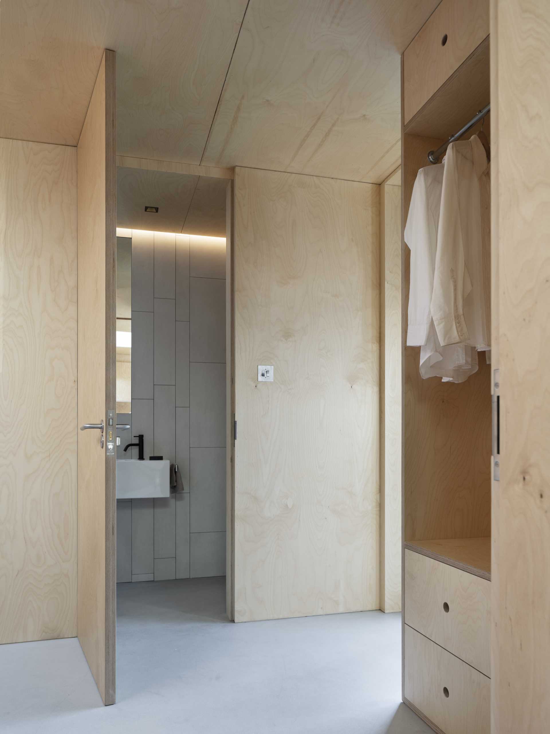 A guest suite with plywood walls and concrete floors.