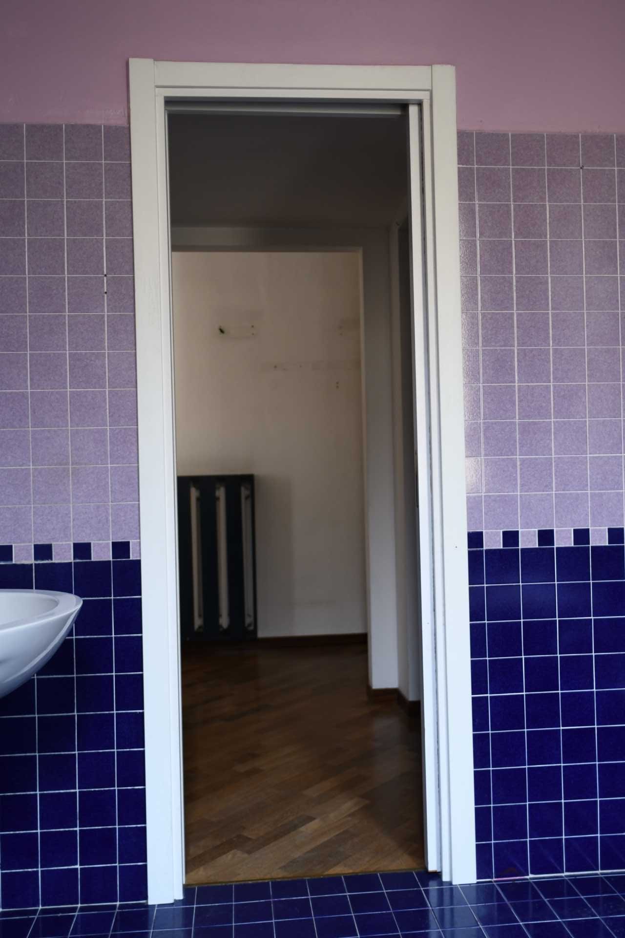 Before photo of a purple-tiled bathroom.