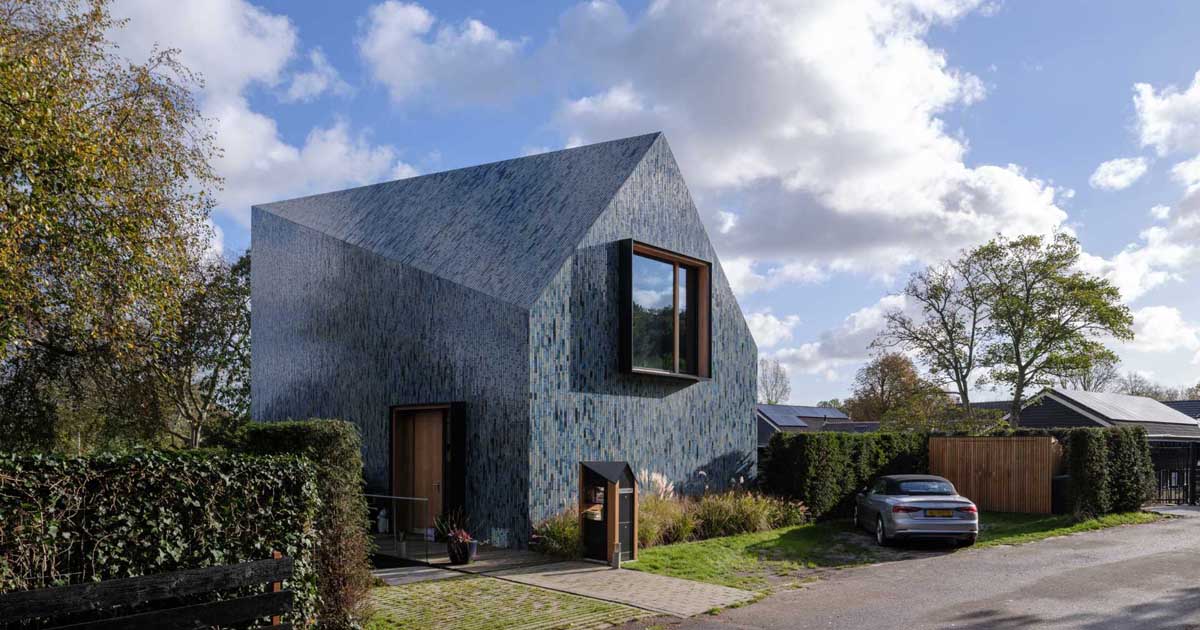 Blue Tiles Cover The Exterior Of This House With A Twisted Roof