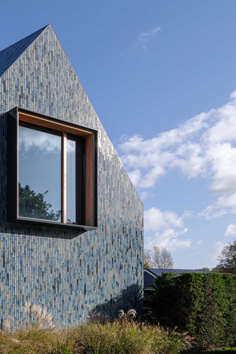 Blue Tiles Cover The Exterior Of This House With A Twisted Roof