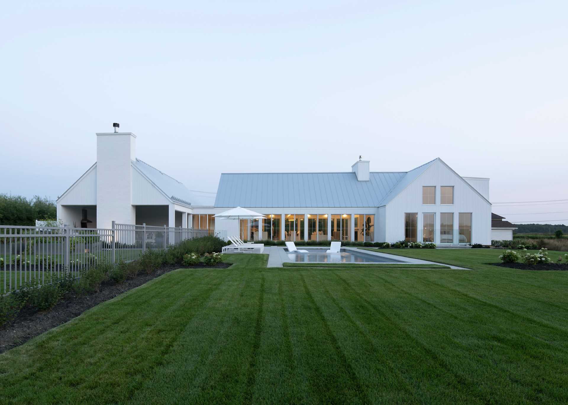 A contemporary home with a swimming pool and landscaped yard.