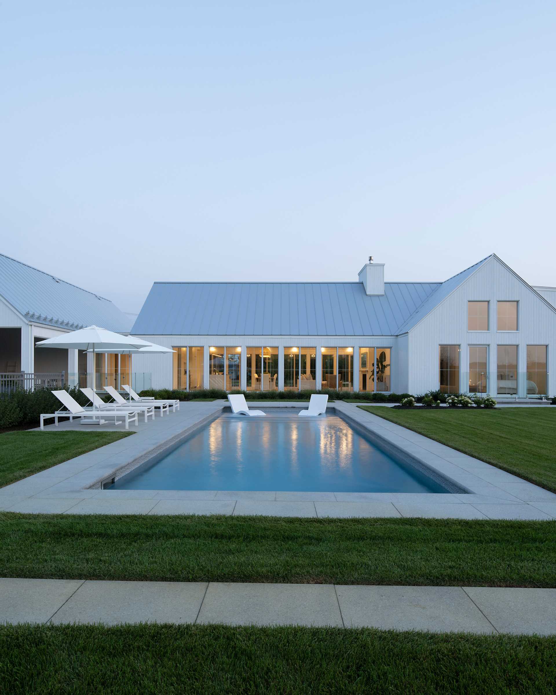 A contemporary home with a swimming pool and landscaped yard.